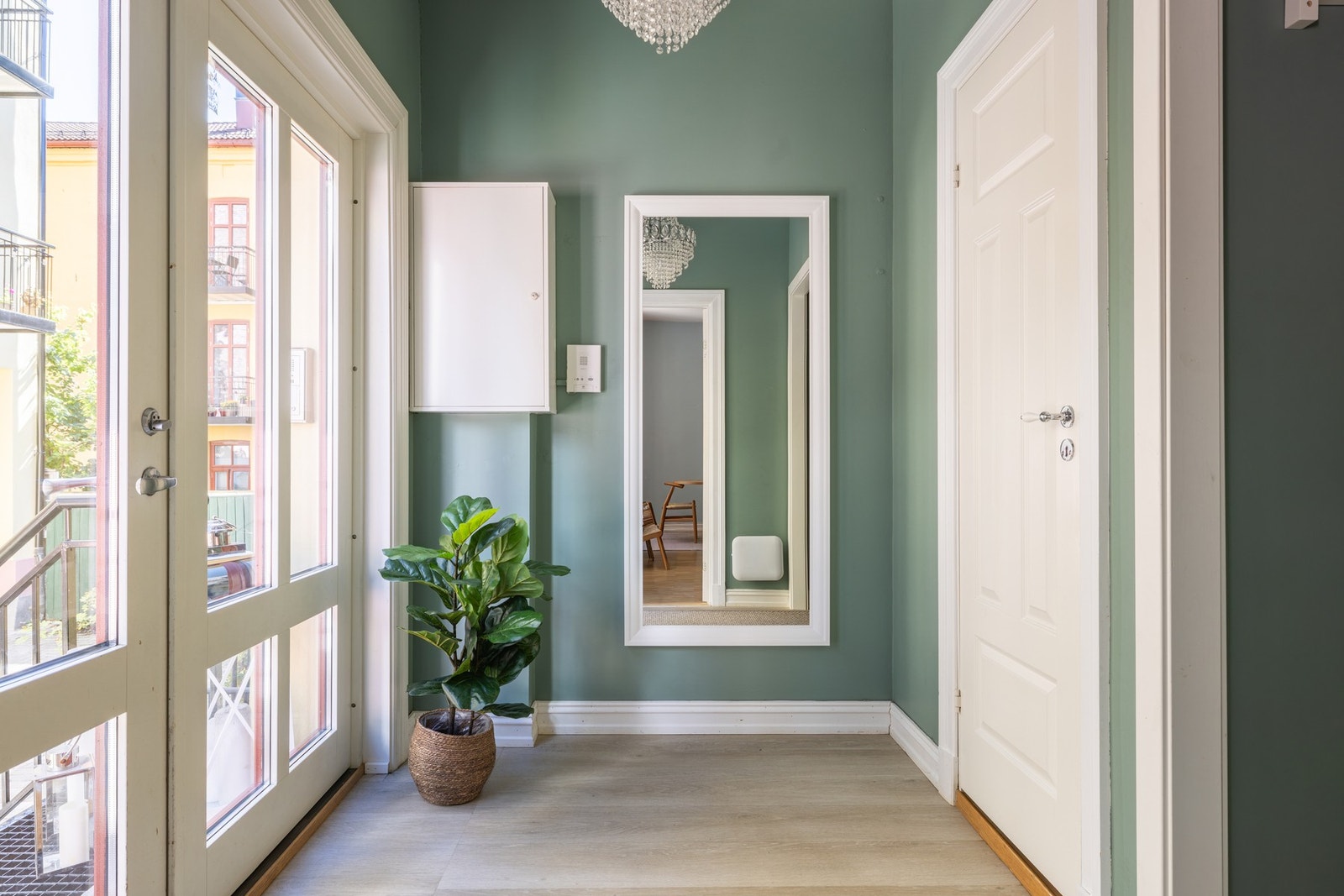 Vel inne er det en fin entré med grønnmalte vegger og enstavs parkettgulv. Gangen ble malt opp og utvidet i 2024. Galleribilde