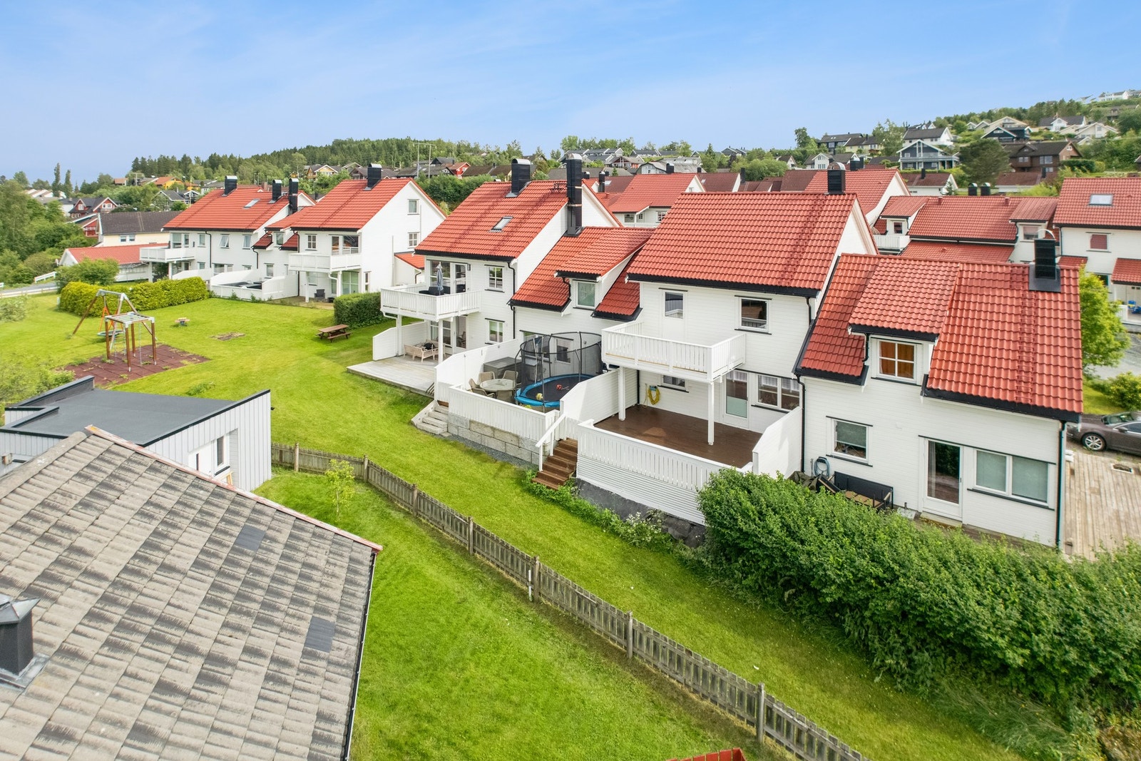 Eiendommen har pent opparbeidet fellesareal med plen, lekeplass og prydbusker. Galleribilde