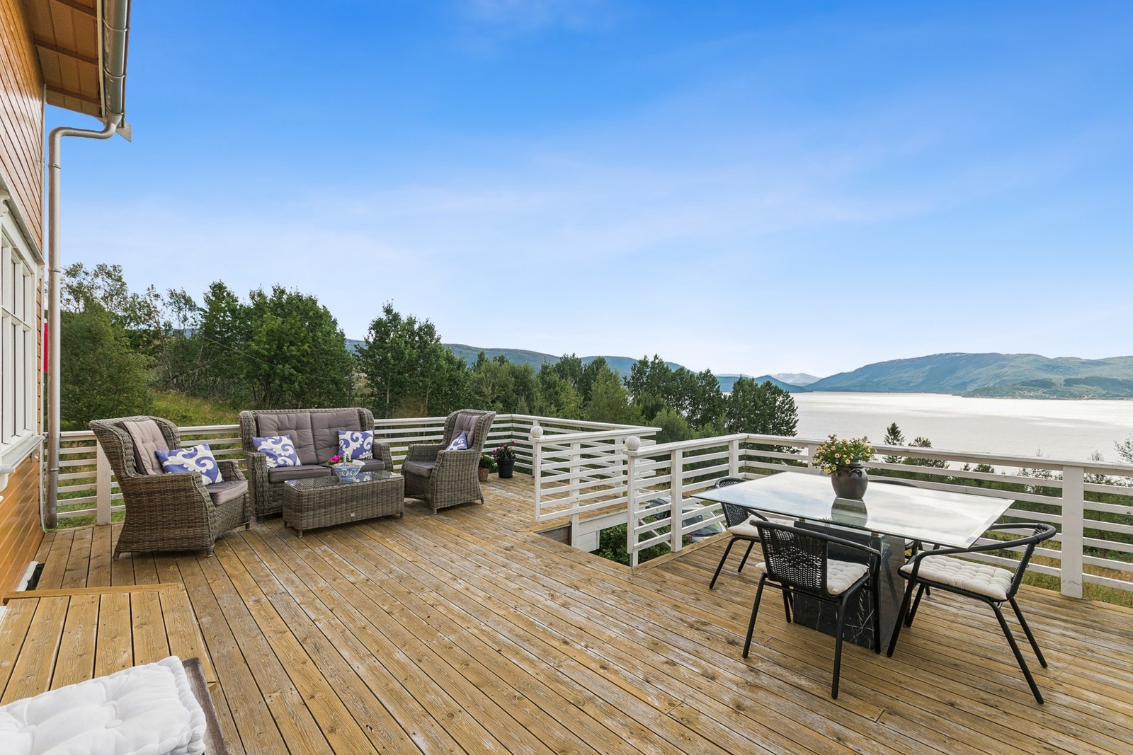 Stor solrik terrasse med vakker utsikt mot sjø og natur. Galleribilde