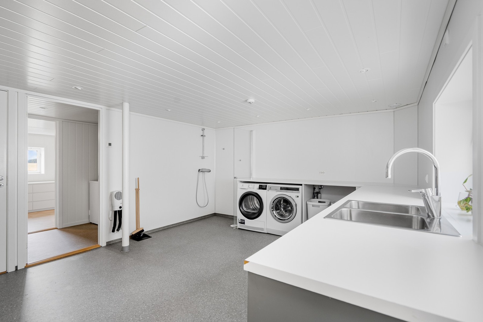 Fra kjøkken går man gjennom en gang før man kommer til et digert, deilig vaskerom med dusjhjørne. Galleribilde