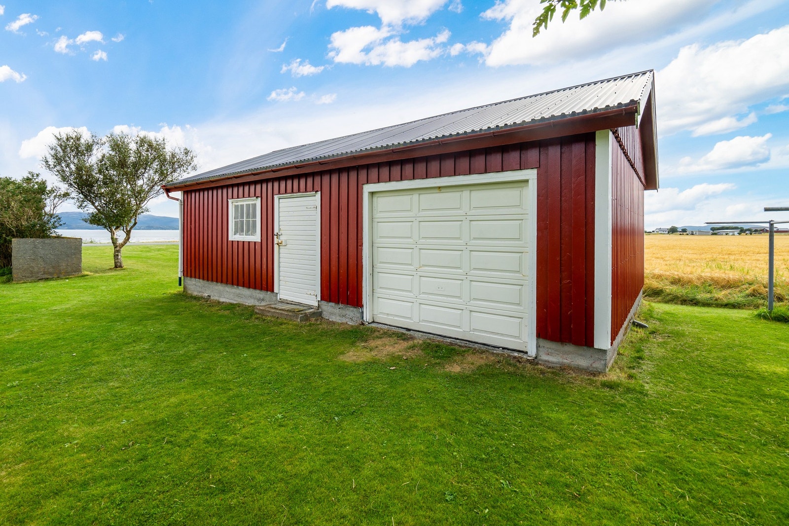 Med tilhørende garasje og uthus. Galleribilde