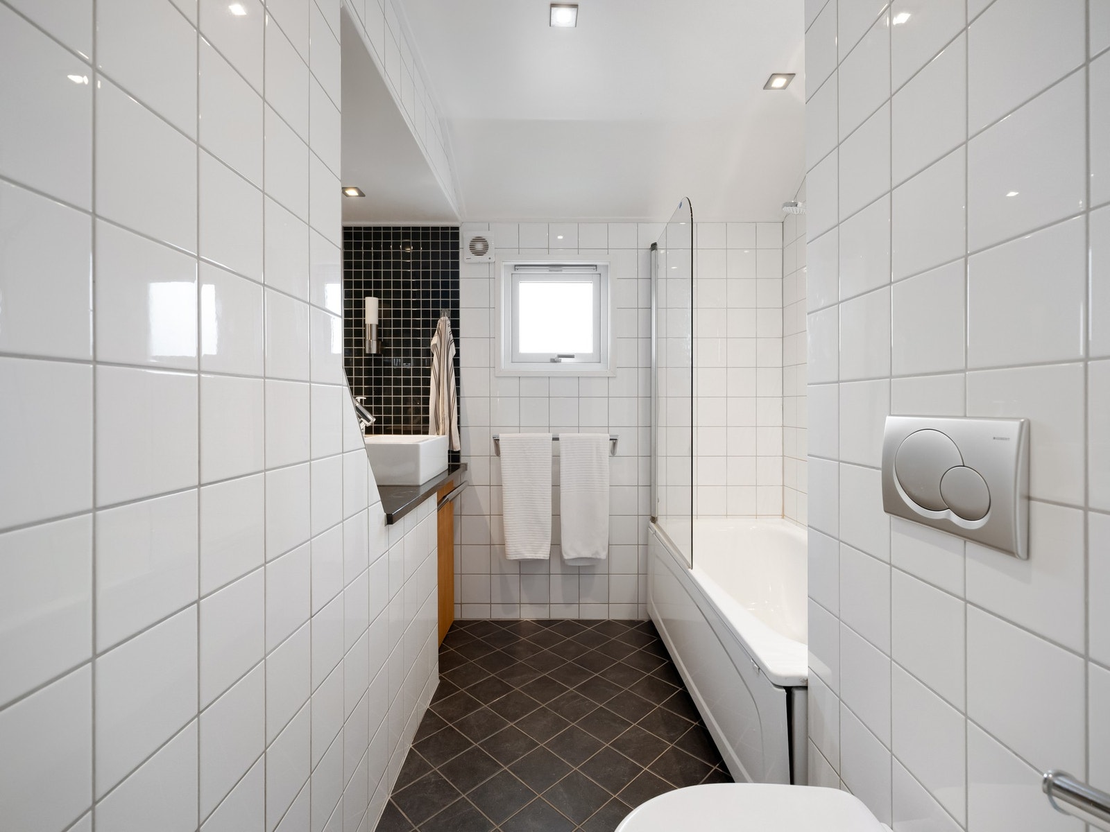 Hovedbadet i boligen ligger i etasjen, og er innredet med badekar med dusj, servant og toalett. Galleribilde