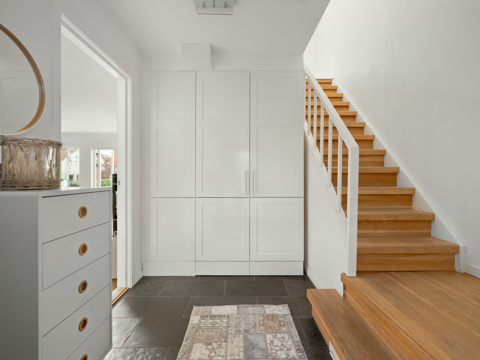 Det er garderobeskap på hver side av inngangsdøren og ved siden av trappen. Galleribilde