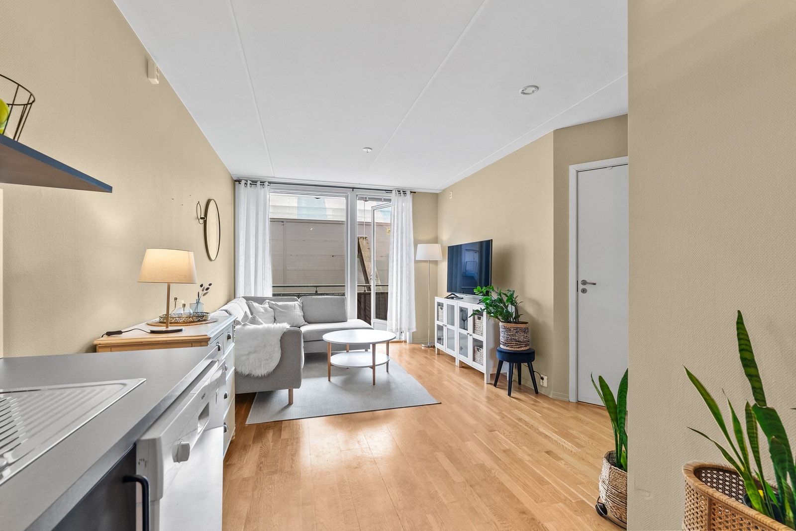 Fra gangen trer vi inn i et sammensatt oppholdsrom. Store glassflater slipper inn rikelig dagslys. Galleribilde