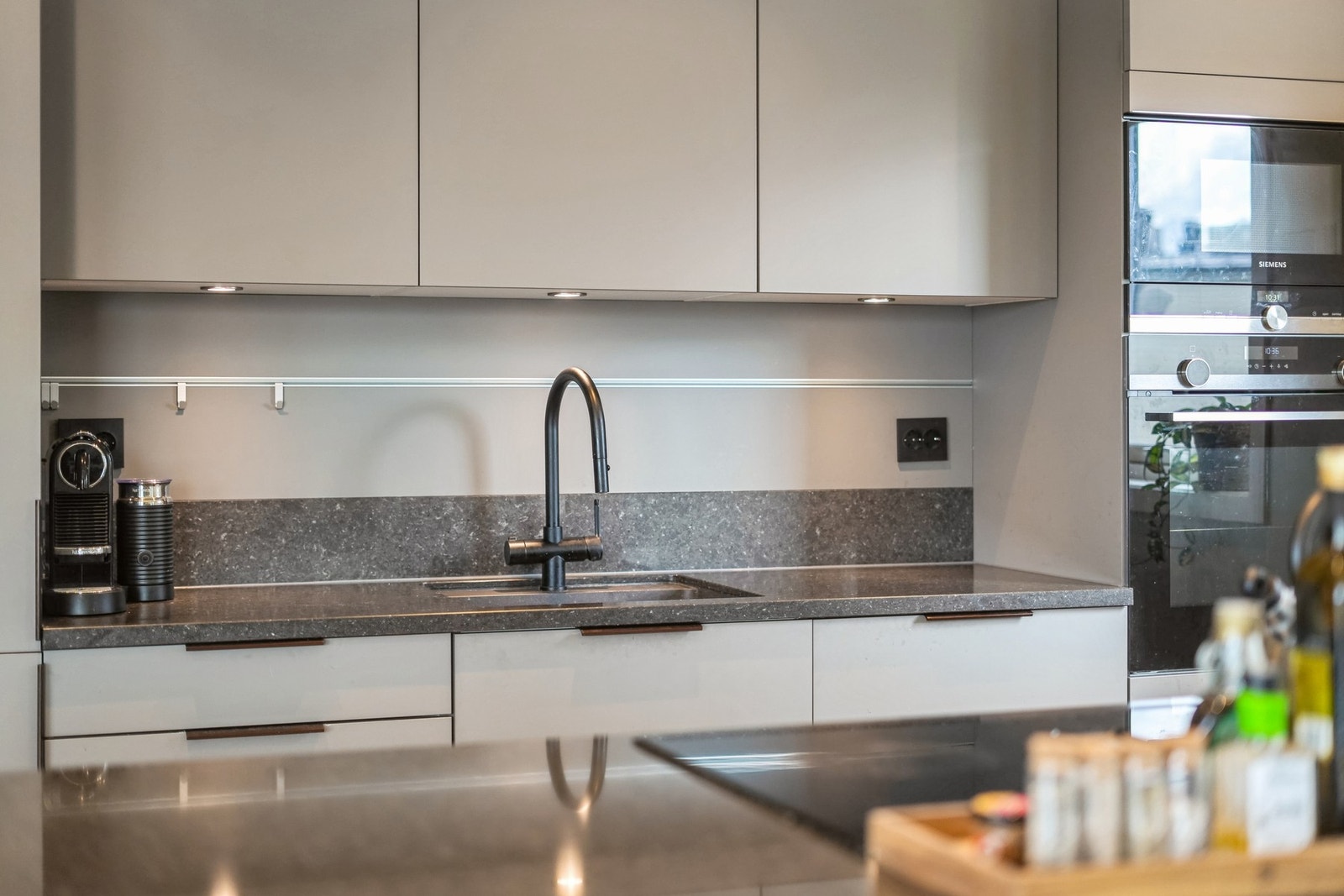 Kokkeleringen gjøres på den stilrene kjøkkenøyen som har induksjon platetopp med kullfiltervifte. Galleribilde