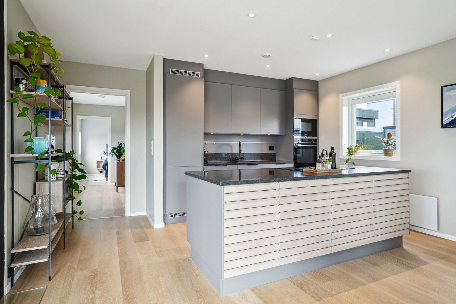 Lekker og funksjonelt kjøkken levert av HTH med mørke slette fronter og steinbenkeplate. Galleribilde