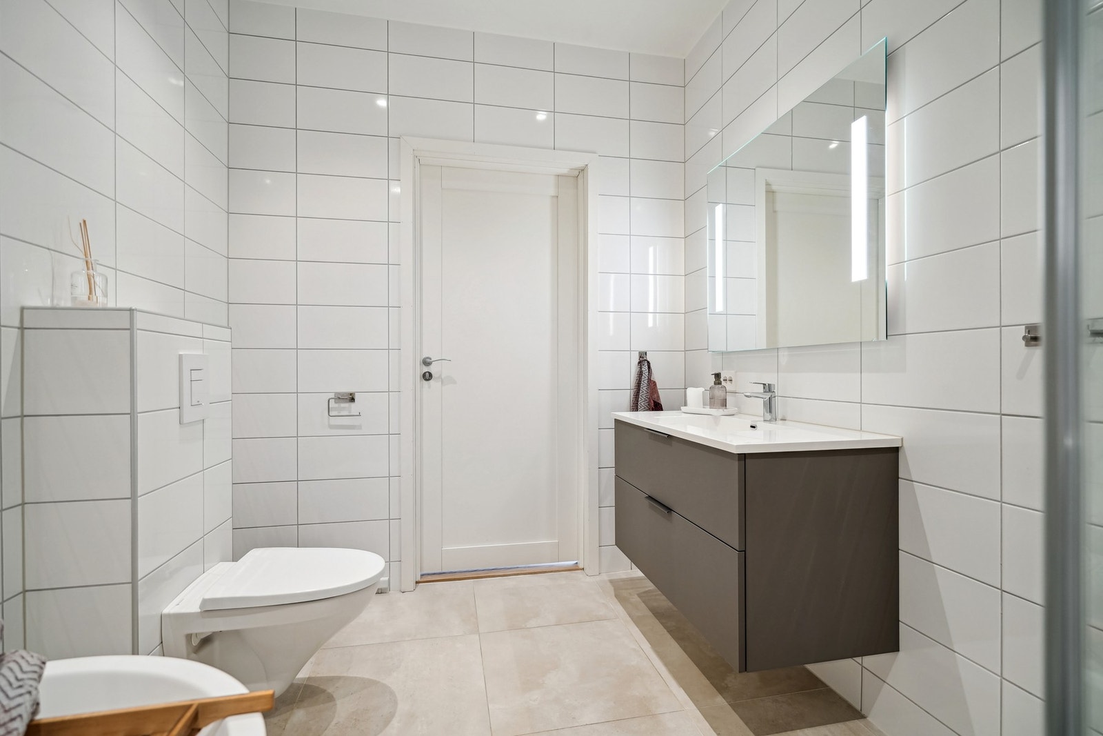 Badet har store 60x60 fliser på gulvet med varmekabler, og veggene er kledd med avlange fliser. I hvit himling er det ledspotter med dimming. Galleribilde