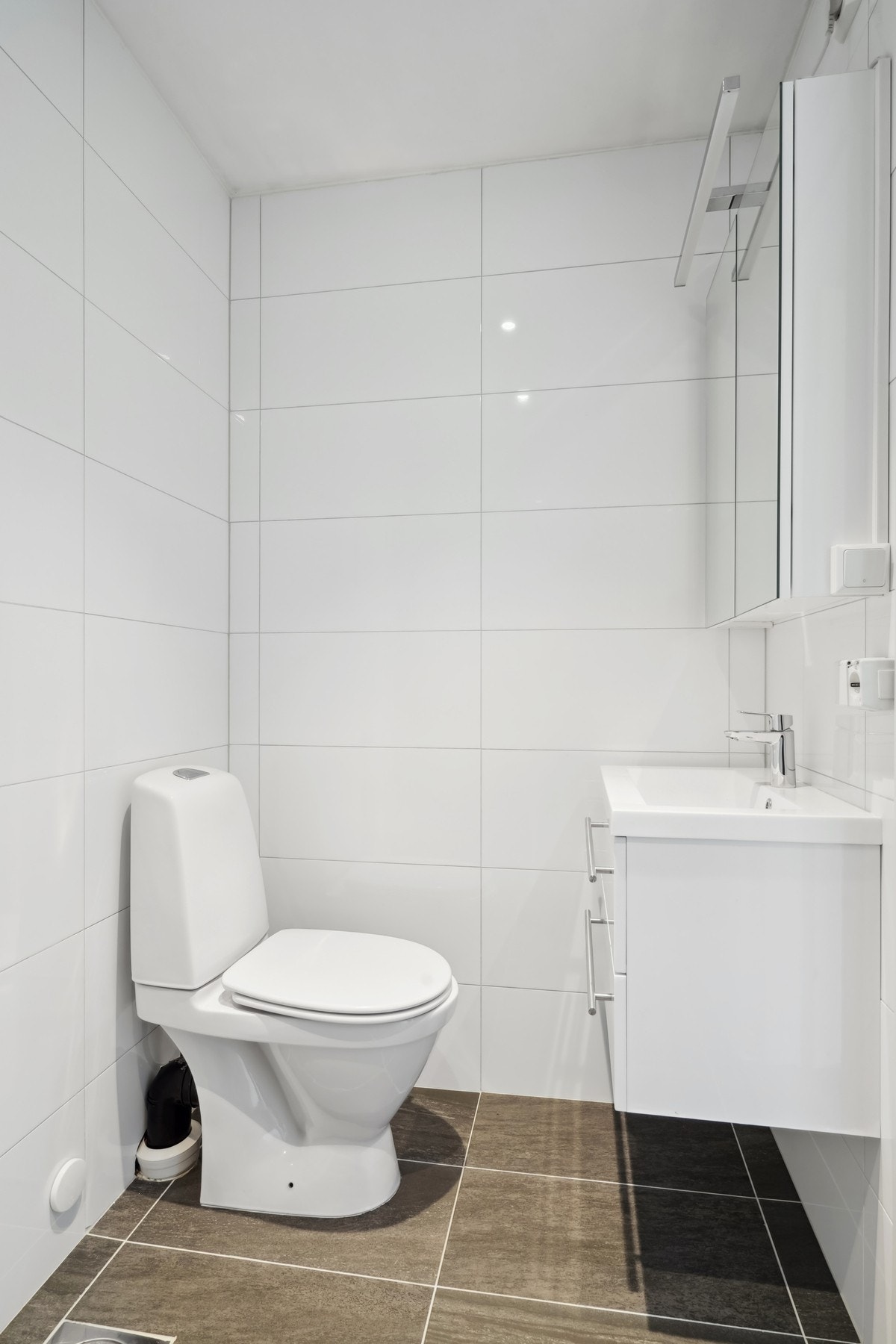 Badet er utstyrt med baderomsmøbel, toalett og dusj med glassvegg. Det er mekanisk avtrekk i rommet. Galleribilde