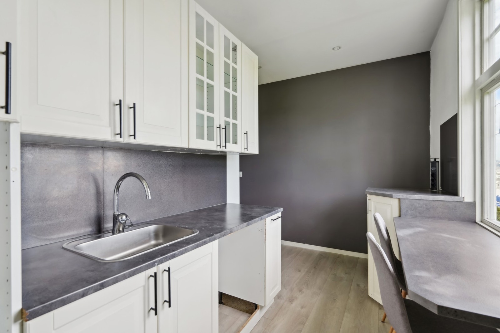 Kjøkkenet er innholdsrikt og har en praktisk utforming med hvite profilerte fronter og laminat benkeplate. Galleribilde