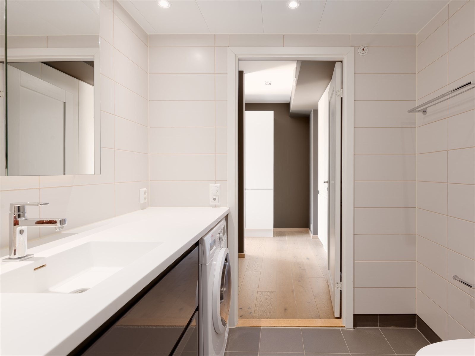 Vegghengt toalett, heldekkende servant, speilskap, dusj og opplegg for vaskemaskin. Galleribilde