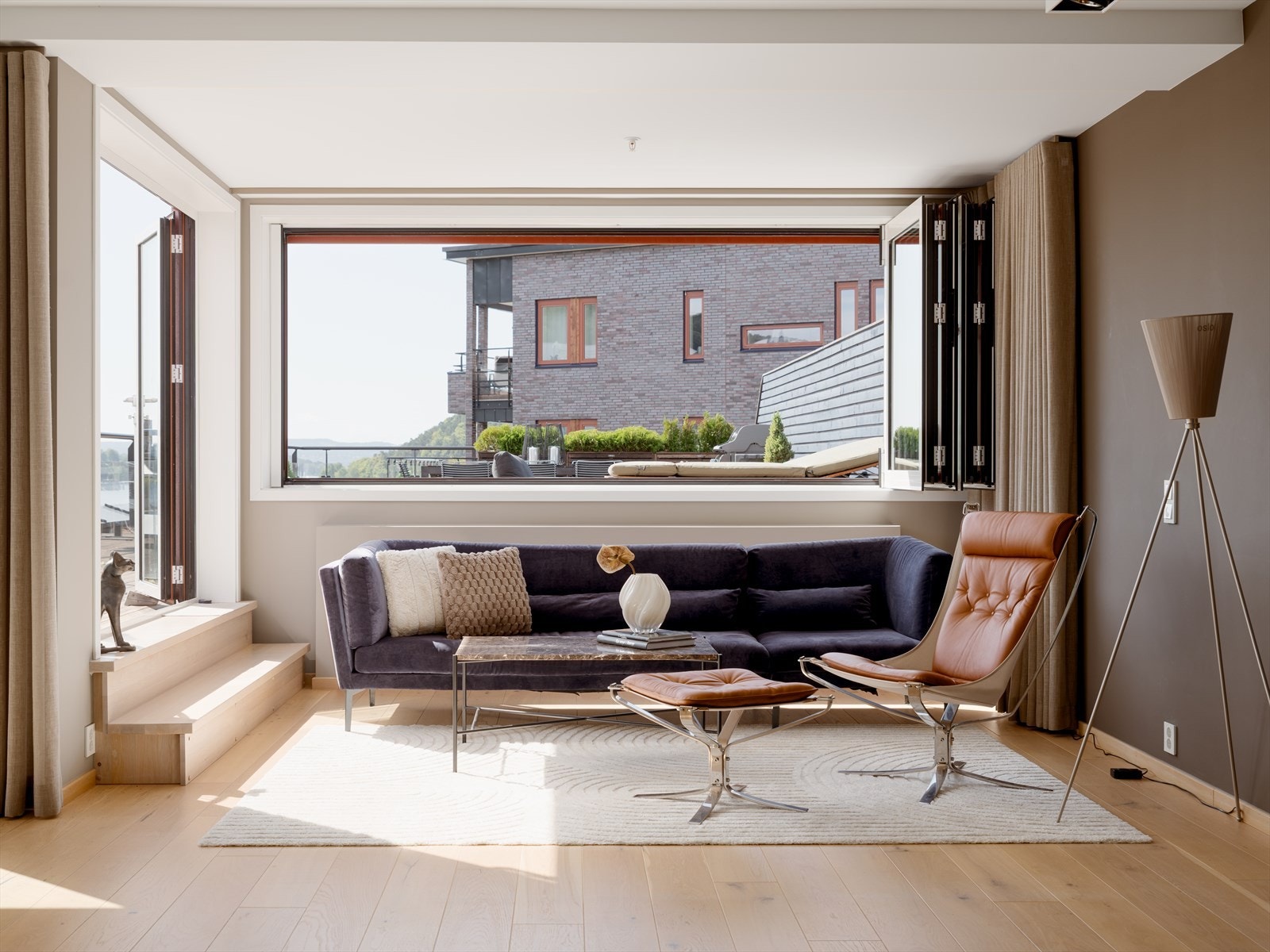 Det er foldedører og foldevinduer fra stuen til terrassen, som skaper en sømløs overgang mellom inne og ute. Galleribilde