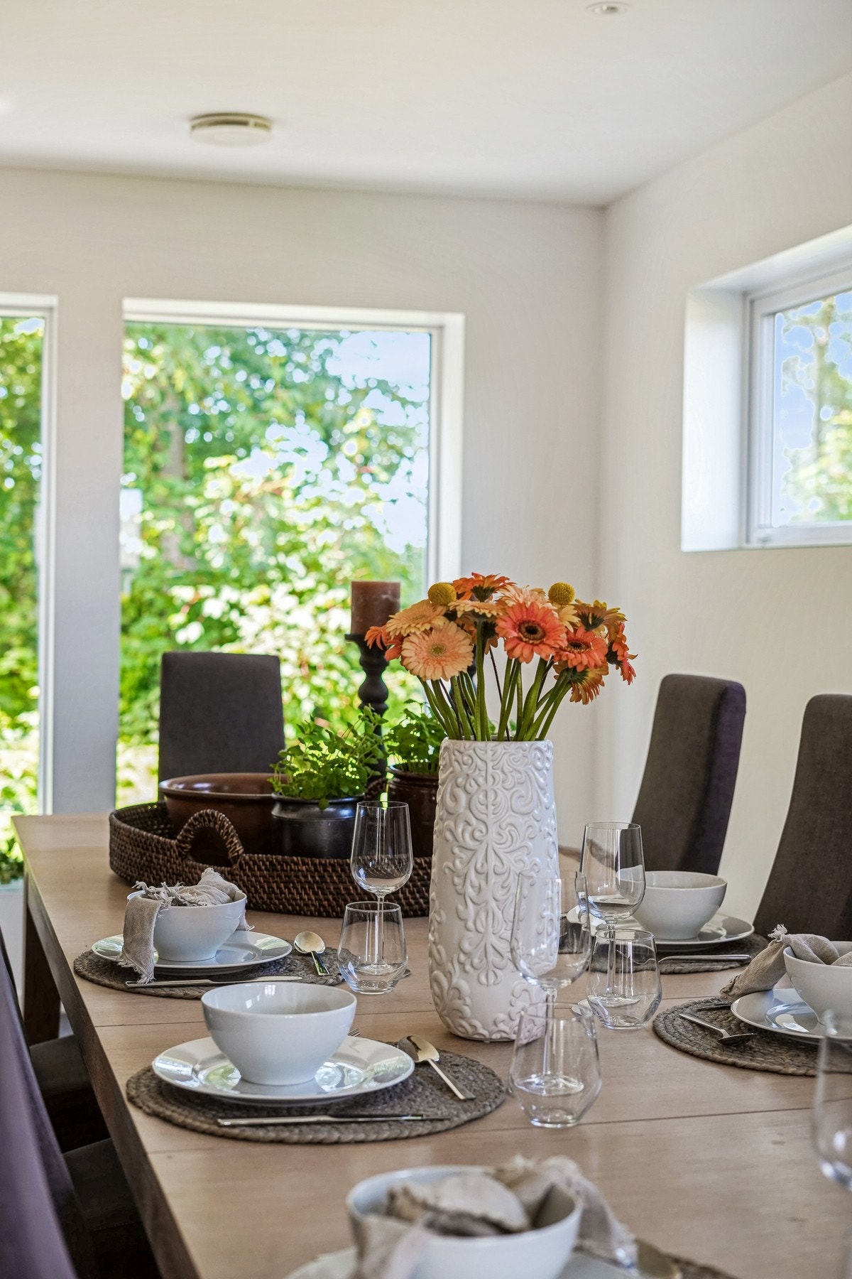 Lyst og trivelig spisegruppe med store vinduer som slipper inn dagslyset og gir en grønn og frisk ramme rundt måltidene. Galleribilde