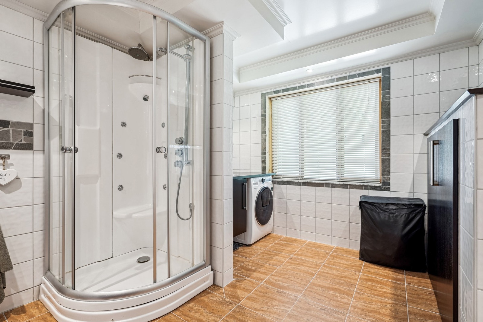 Helfliset bad/vaskerom med elektriske varmekabler. Innredet med beiset benkeplate med nedfelt stålkum, opplegg for vaskemaskin - Galleribilde