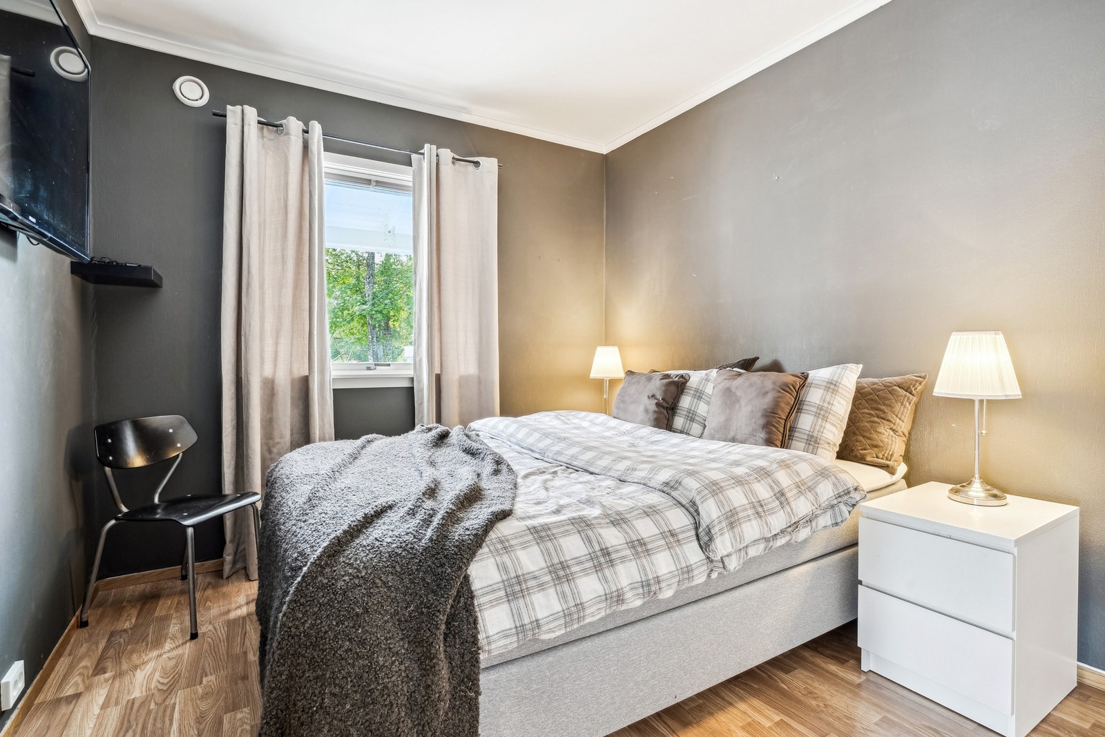 Soverom innredet med dobbeltseng og nattbord på hver side. Galleribilde