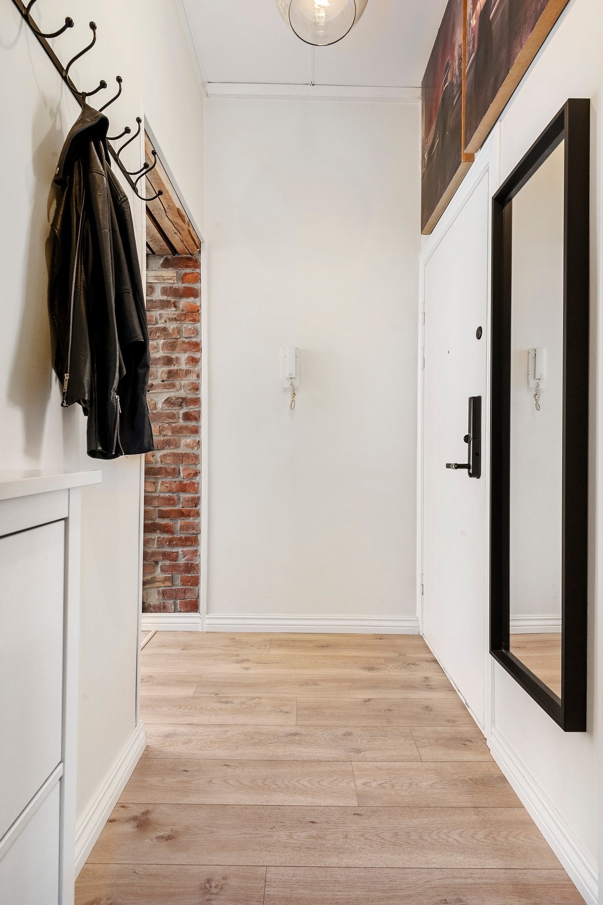 Leiligheten har en lys og innbydende entré. Legg merke til kontrastveggen med teglverksstein Galleribilde