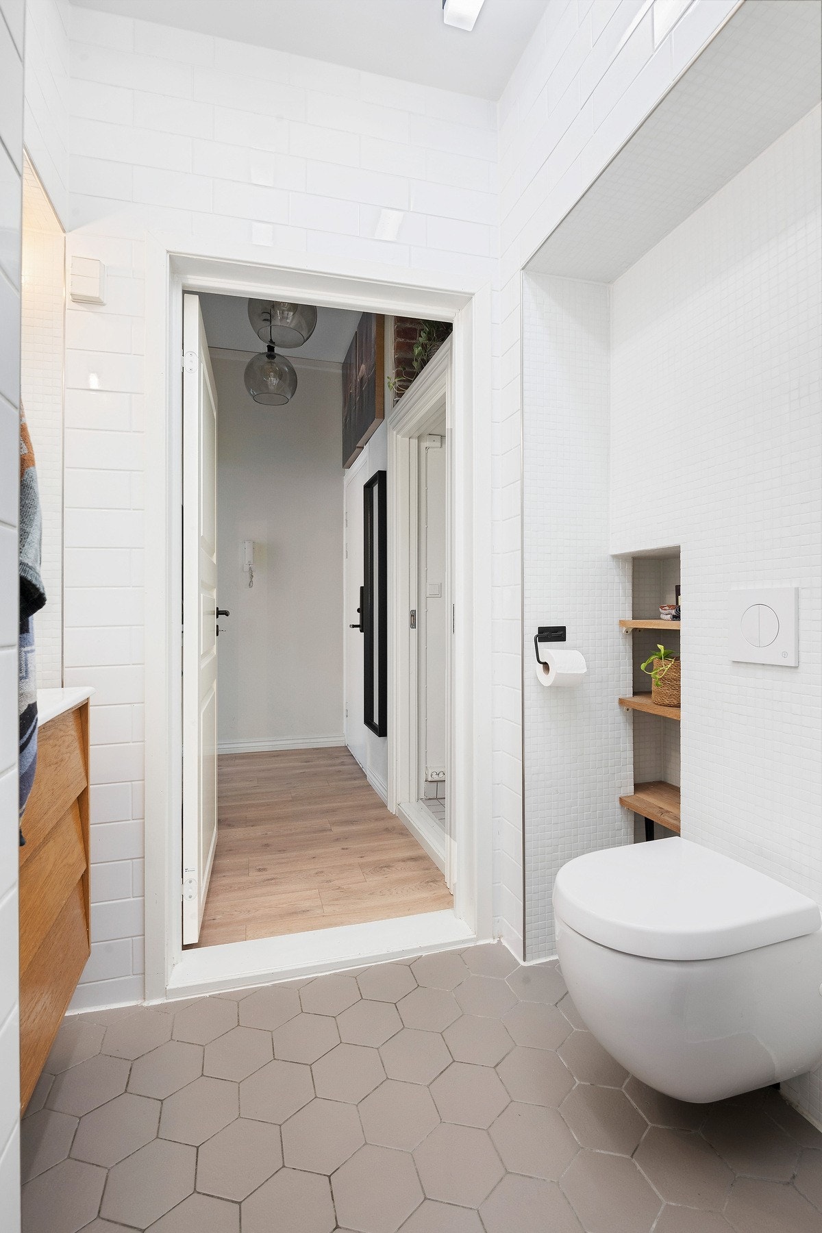 Rommet er innredet med vegghengt servantinnredning, vegghengt toalett og dusjhjørne med glassdører og regndusj Galleribilde