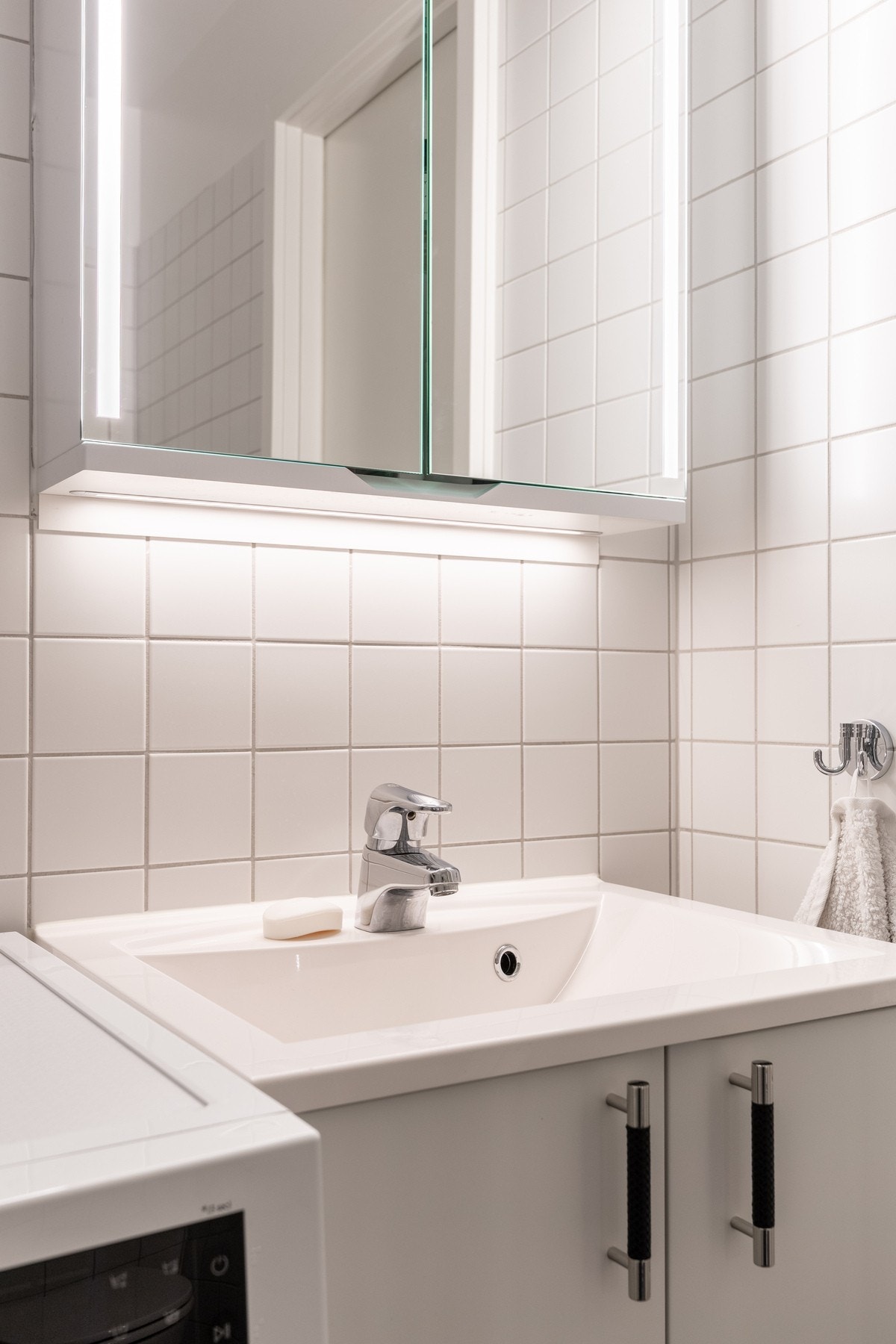 Badet er innredet med vegghengt servantskap, vegghengt speilskap, dusjhjørne med innfellbare glassdører, samt vegghengt toalett. Galleribilde