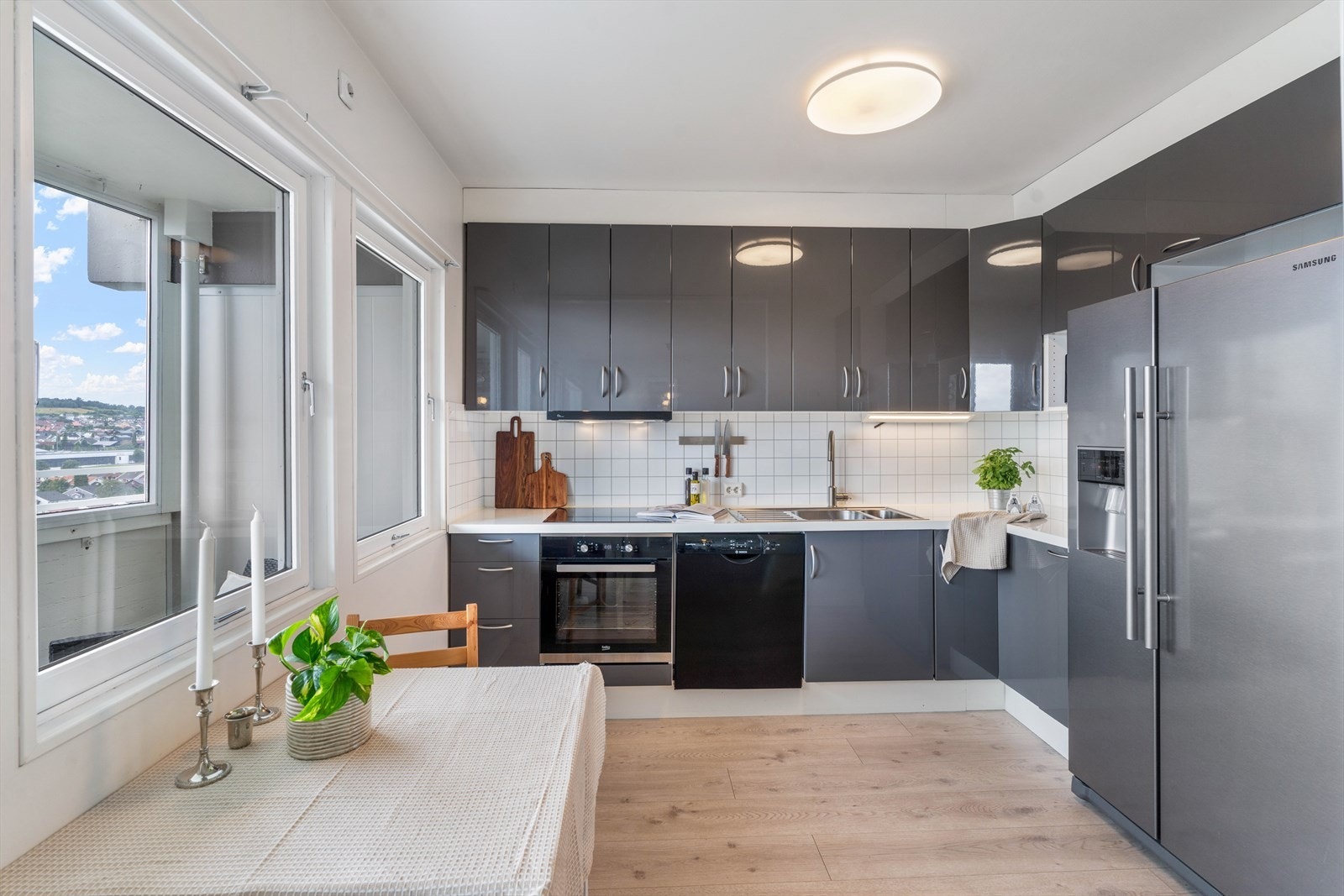Flott og romslig kjøkken med stilrent design og hvitevarer som blant annet kjøl/fryseskap, oppvaskmaskin, platetopp, stekeovn og vannstoppsystem Galleribilde