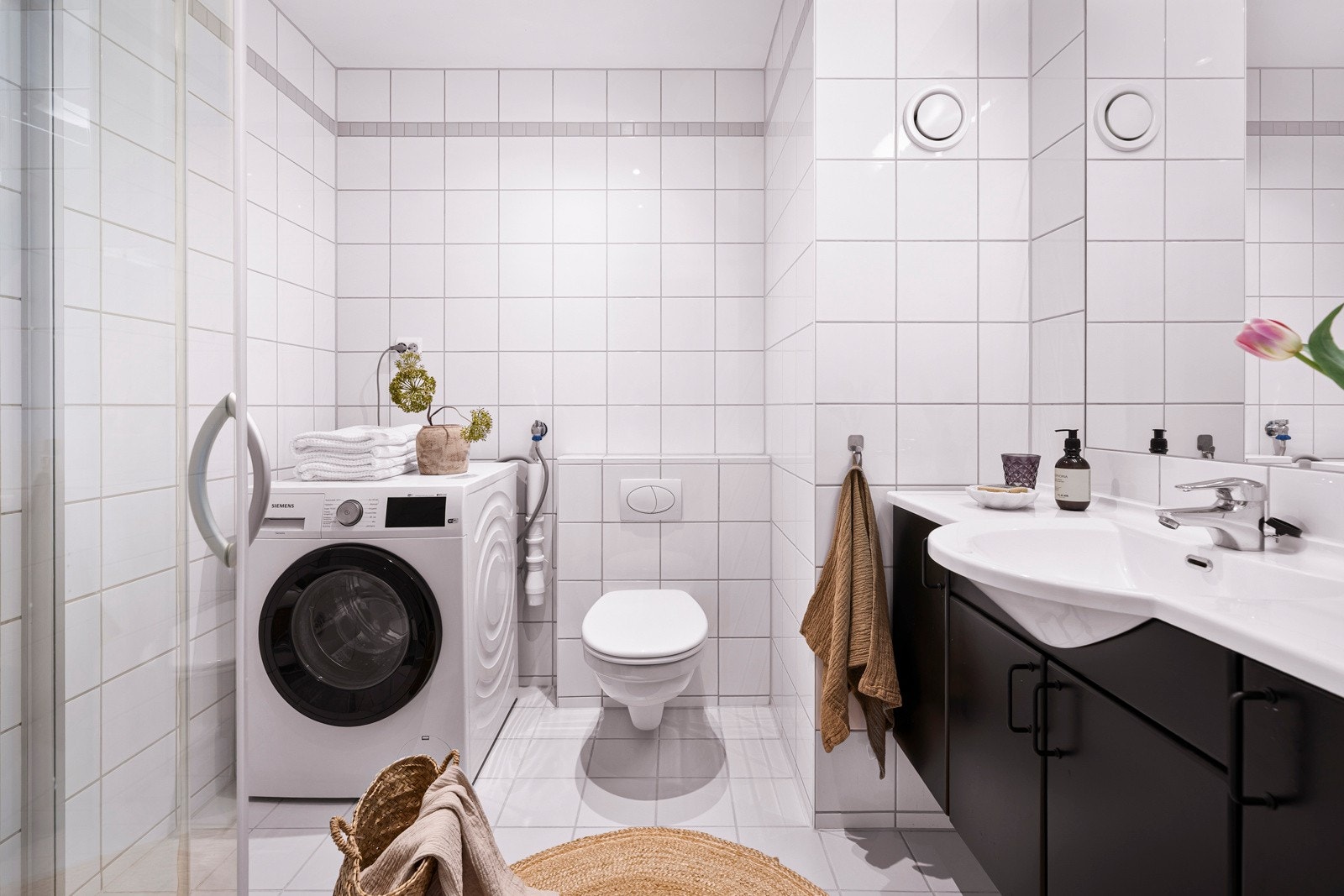 Badet er pent med lyse fliser på gulv og vegger, vannbåren gulvvarme og downlights i taket. Galleribilde