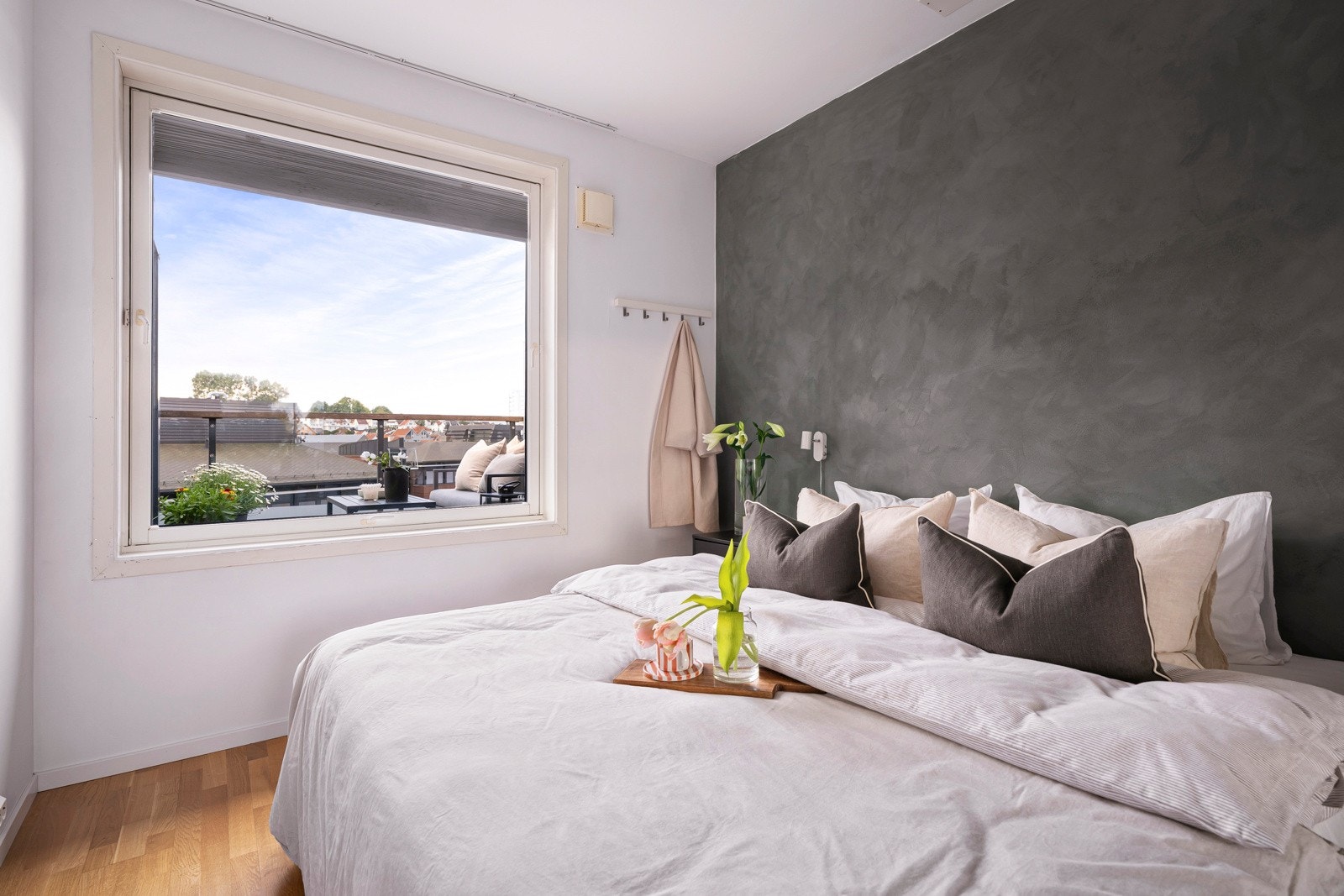 På motsatt side av rommet er det montert en stor skyvedørsgarderobe med hvite fronter og speil. Galleribilde