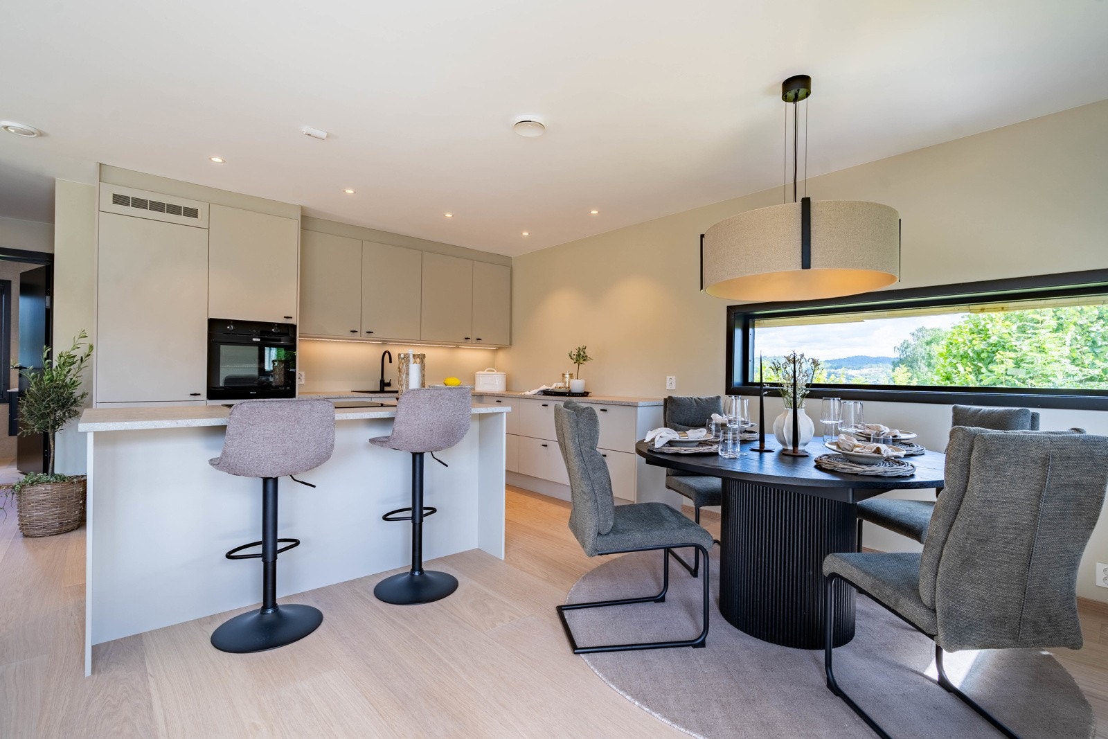 Kjøkkenet er både praktisk og elegant, med glatte fronter og laminat benkeplate. Her finner du integrerte hvitevarer som kjøl/fryseskap, oppvaskmaskin, komfyr og platetopp, samt nedfelt sort komposittvask med ettgreps blandebatteri. Galleribilde