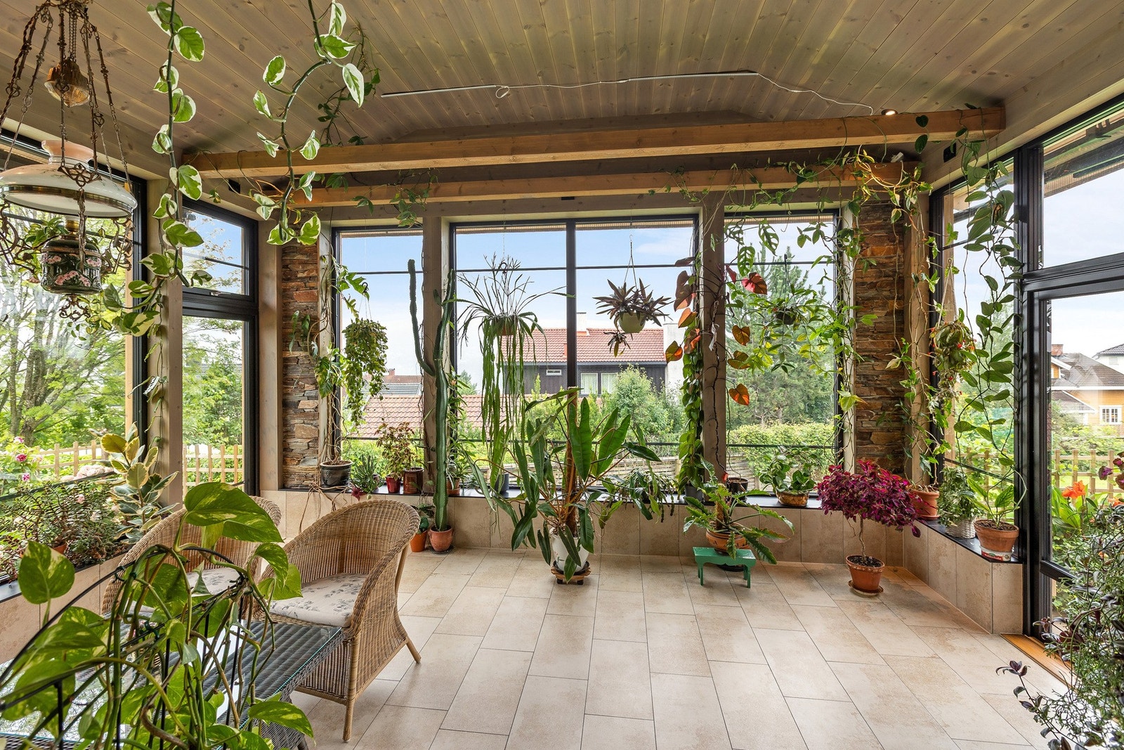 Rommet har flislagt gulv med god plass til både sittegruppe og beplantning, noe som skaper en lun og grønn atmosfære året rundt. Galleribilde