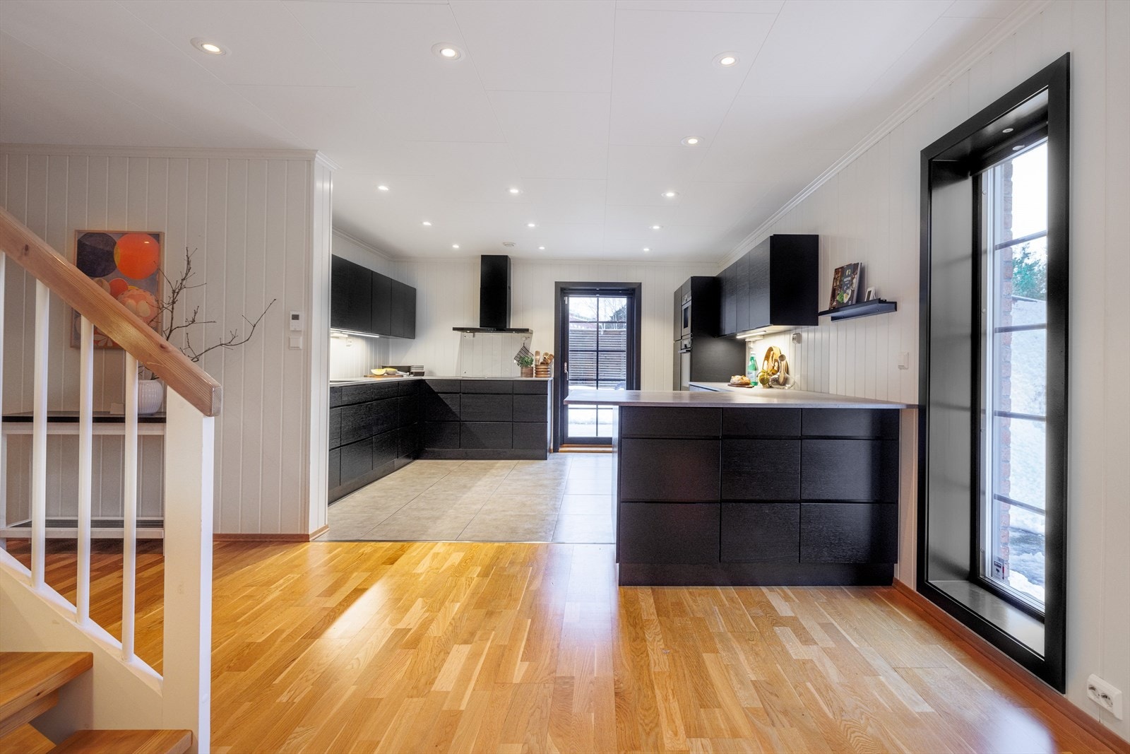 Husets kjøkken er et blikkfang med svartbeisede eikefronter, integrerte hvitevarer og godt med oppbevaringsplass. Galleribilde