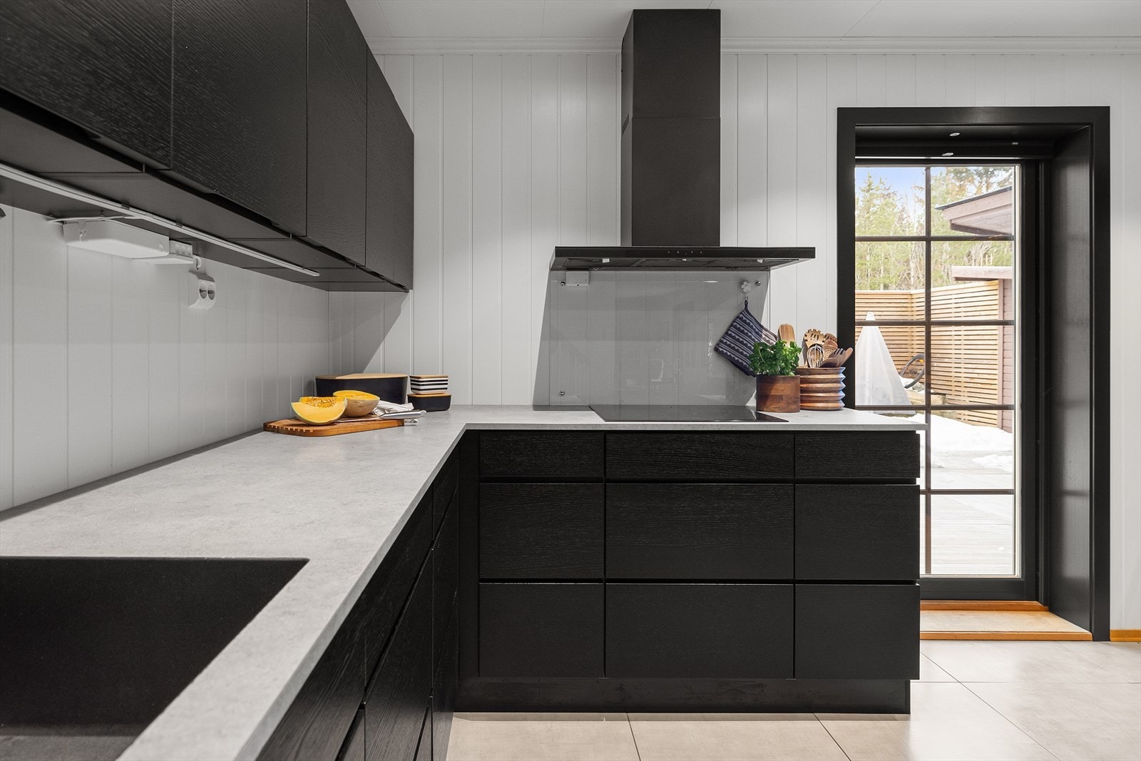 Fra kjøkkenet er det direkte utgang til den solrike verandaen, noe som er praktisk om sommeren når man har behov for enkel tilgang til matvarer som skal ut på grillen. Galleribilde