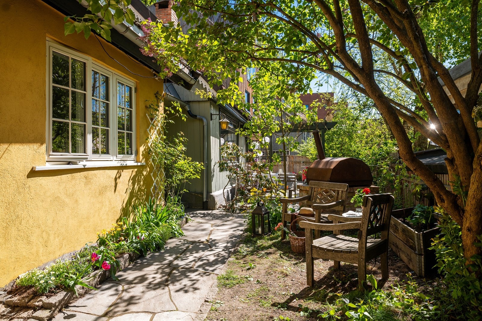 Den frodige og sjarmerende hagen er en ekte oase, fylt med blomstrende planter, løvtrær som gir deilig skygge, og blomsterbed som gir deg muligheten til å dyrke dine egne råvarer. Galleribilde