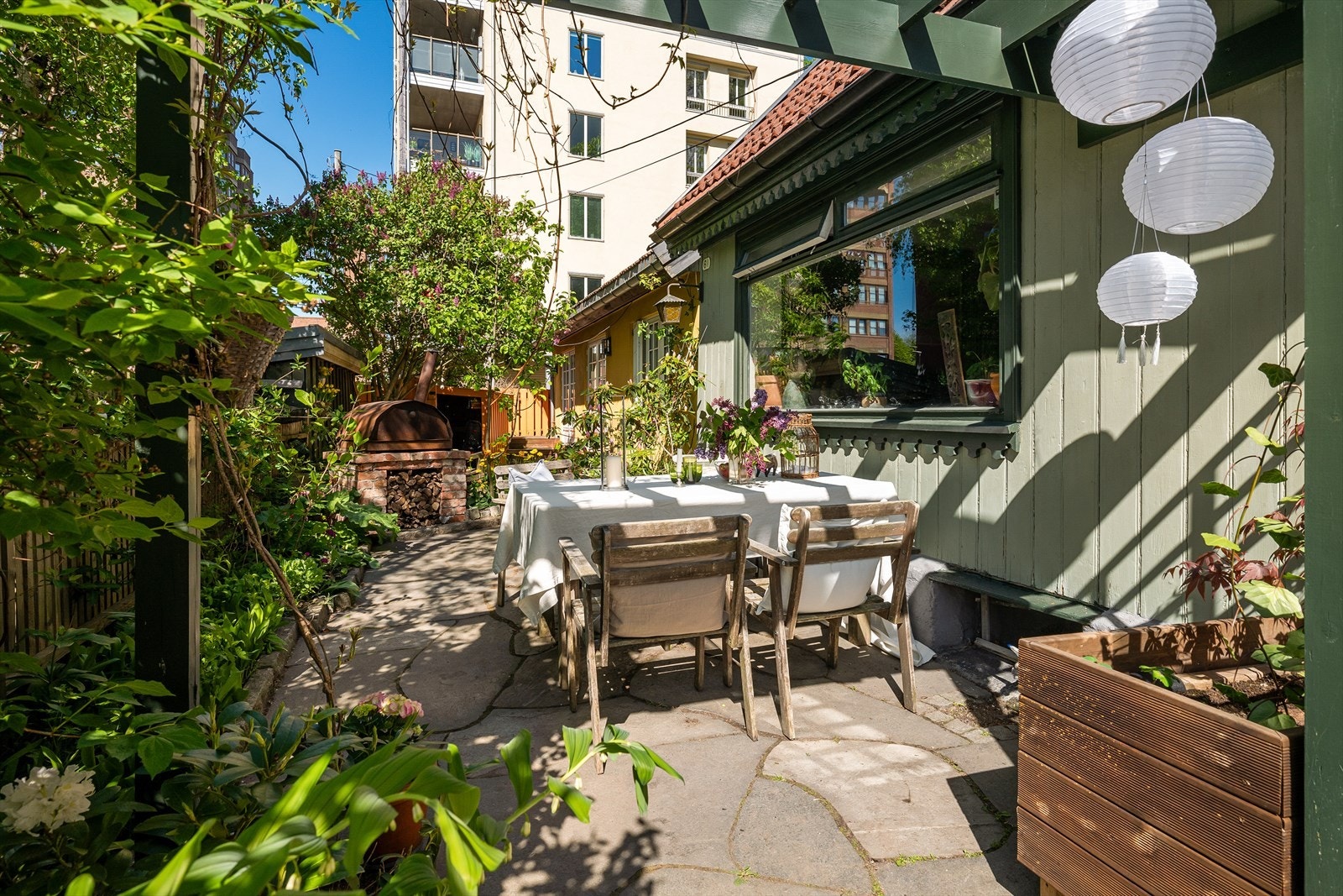 På den skiferlagte uteplassen er det god plass til et stort spisebord og grill. Galleribilde