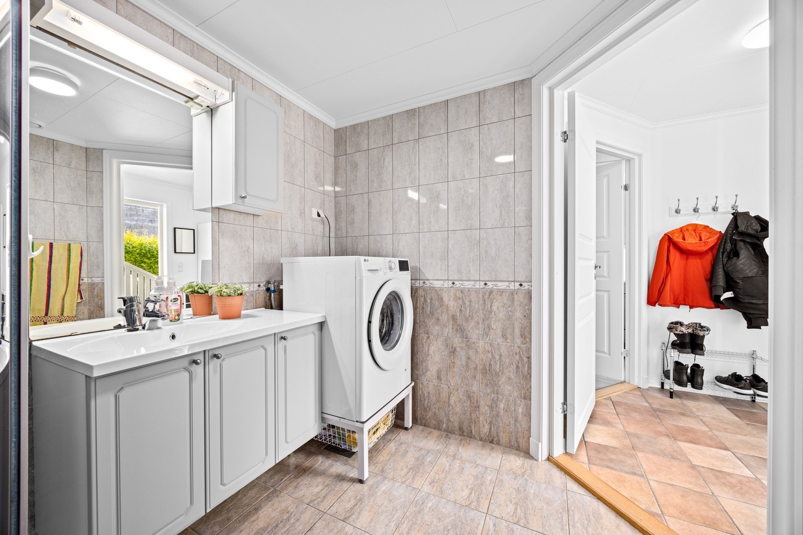 Badet har innredning med nedfelt servant, toalett, dusjkabinett og opplegg for vaskemaskin Galleribilde