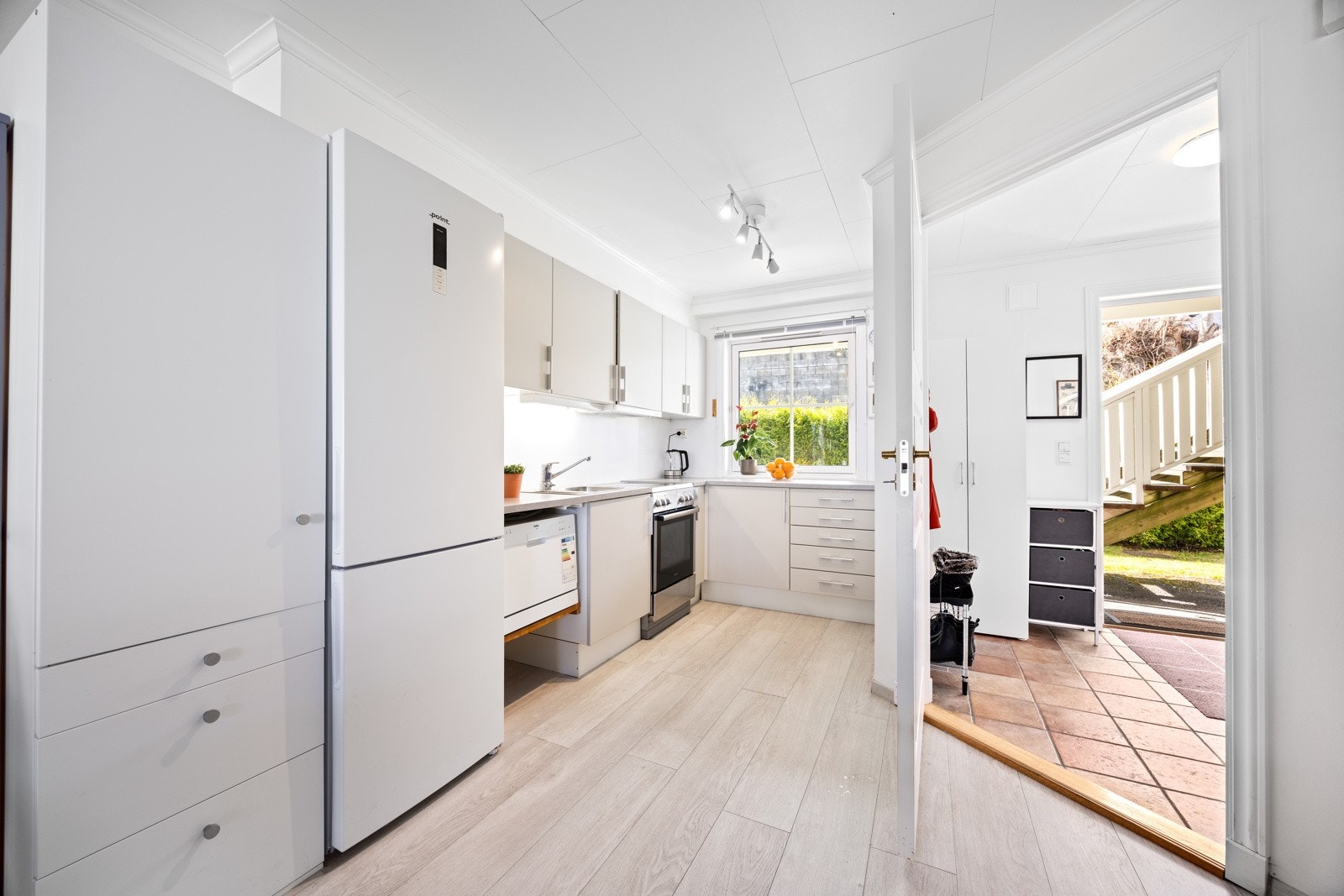 Lyst og trivelig kjøkken som har innredning med glatte fronter, godt med skap- og benkeplass. Galleribilde