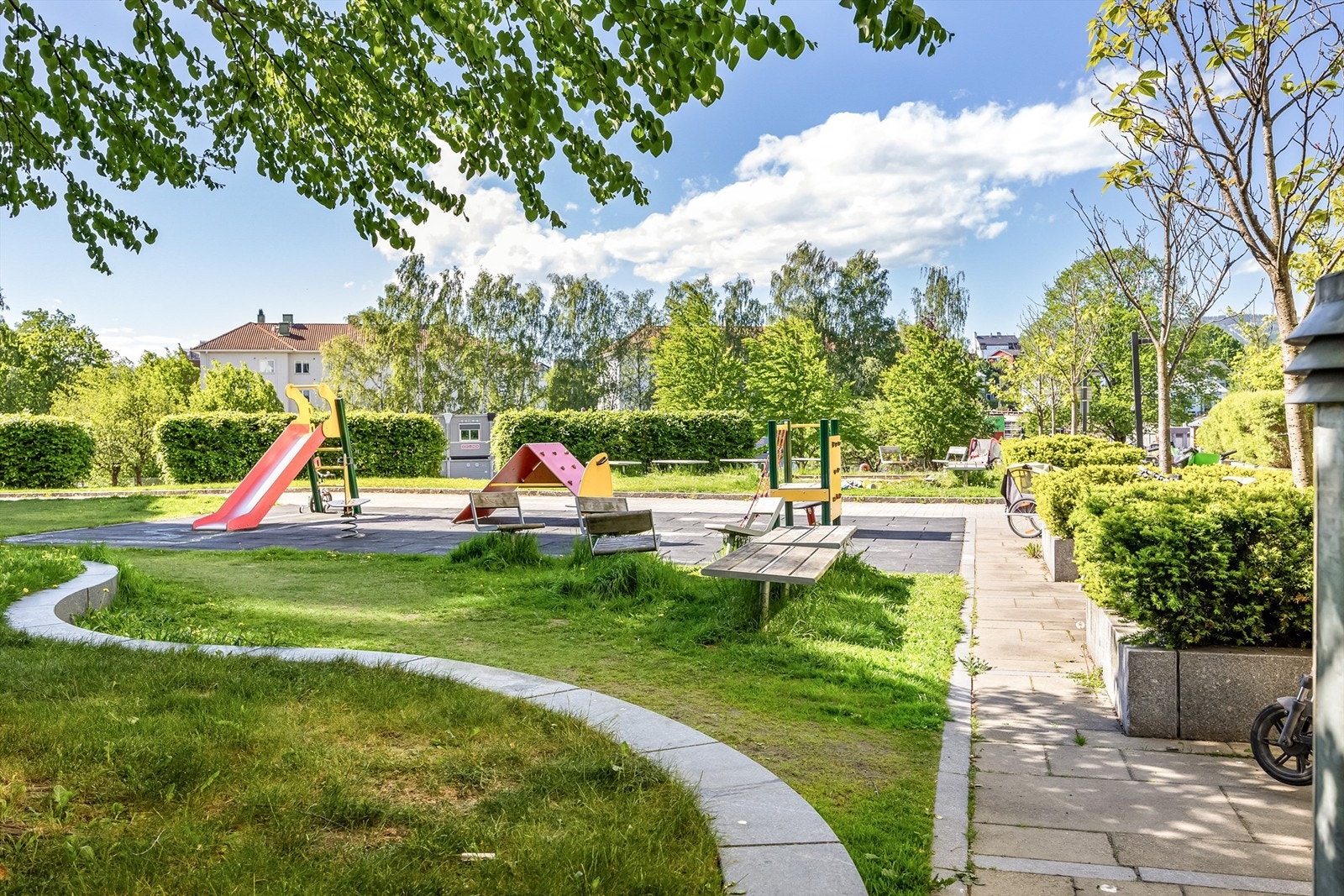 Fellesområde opparbeidet med blant annet asfalterte og steinsatte adkomst-/internveier, sittebenker, sykkelstativer, lekeapparater, plenarealer, busker og trær. Galleribilde