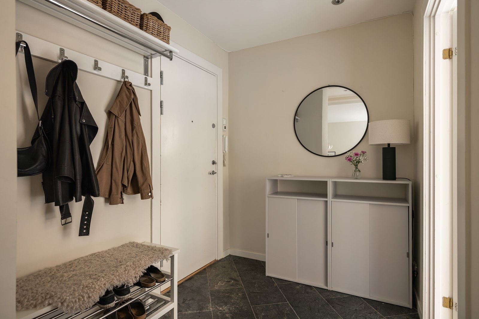 Praktisk og romslig flislagt entré med plass til å sette fra seg sko og henge fra seg yttertøy Galleribilde