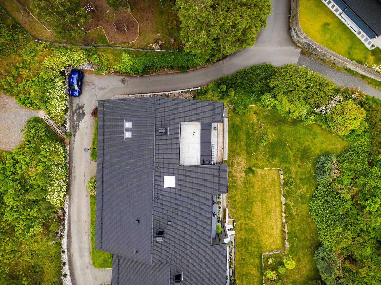 - Området rundt boligen er pent opparbeidet med grønn plen og frodig beplantning - Galleribilde