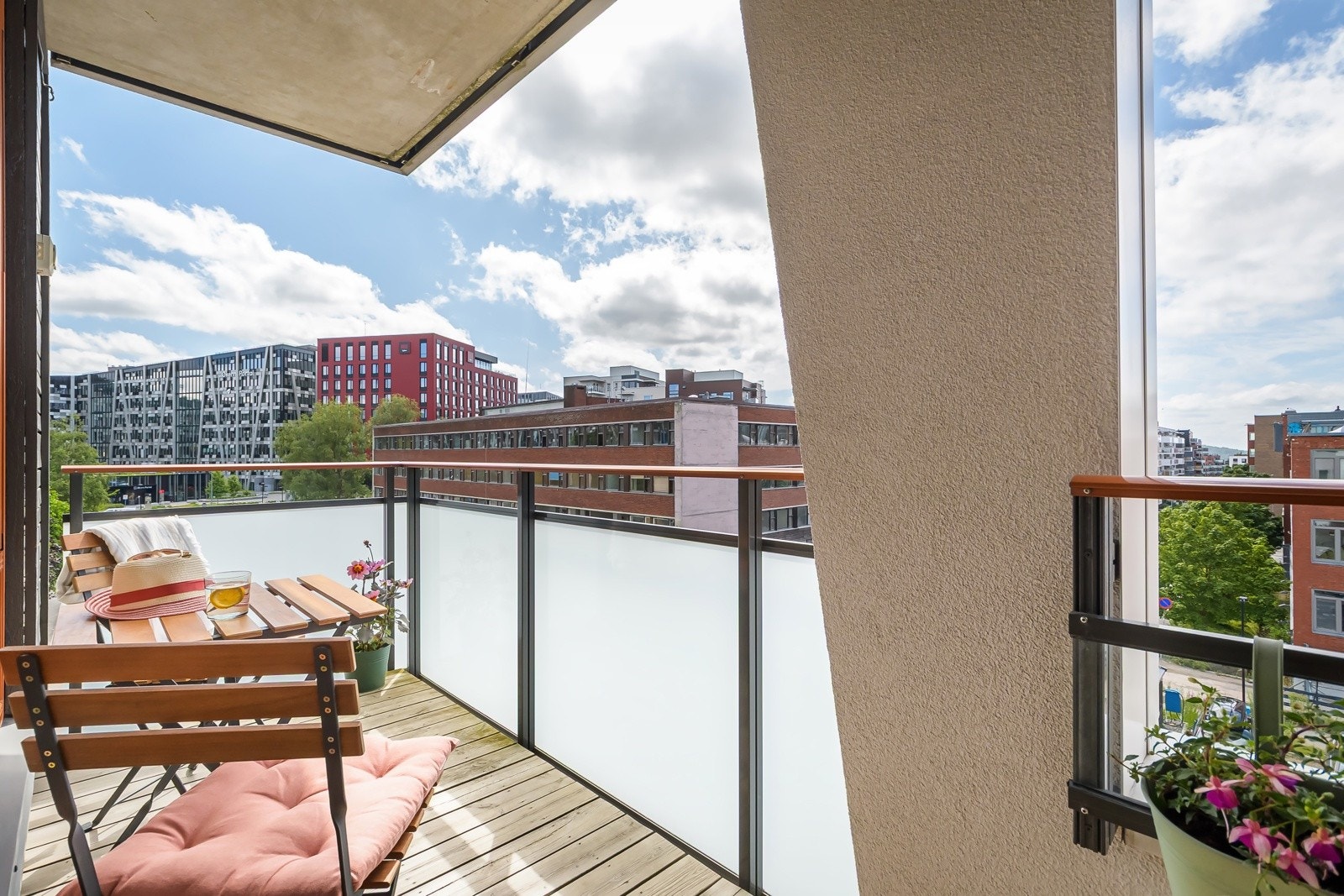 Også denne balkongen er overbygget, har terrassebord på gulv, rekkverk med frostede glassfelt, utebelysning og stikkontakt. Galleribilde