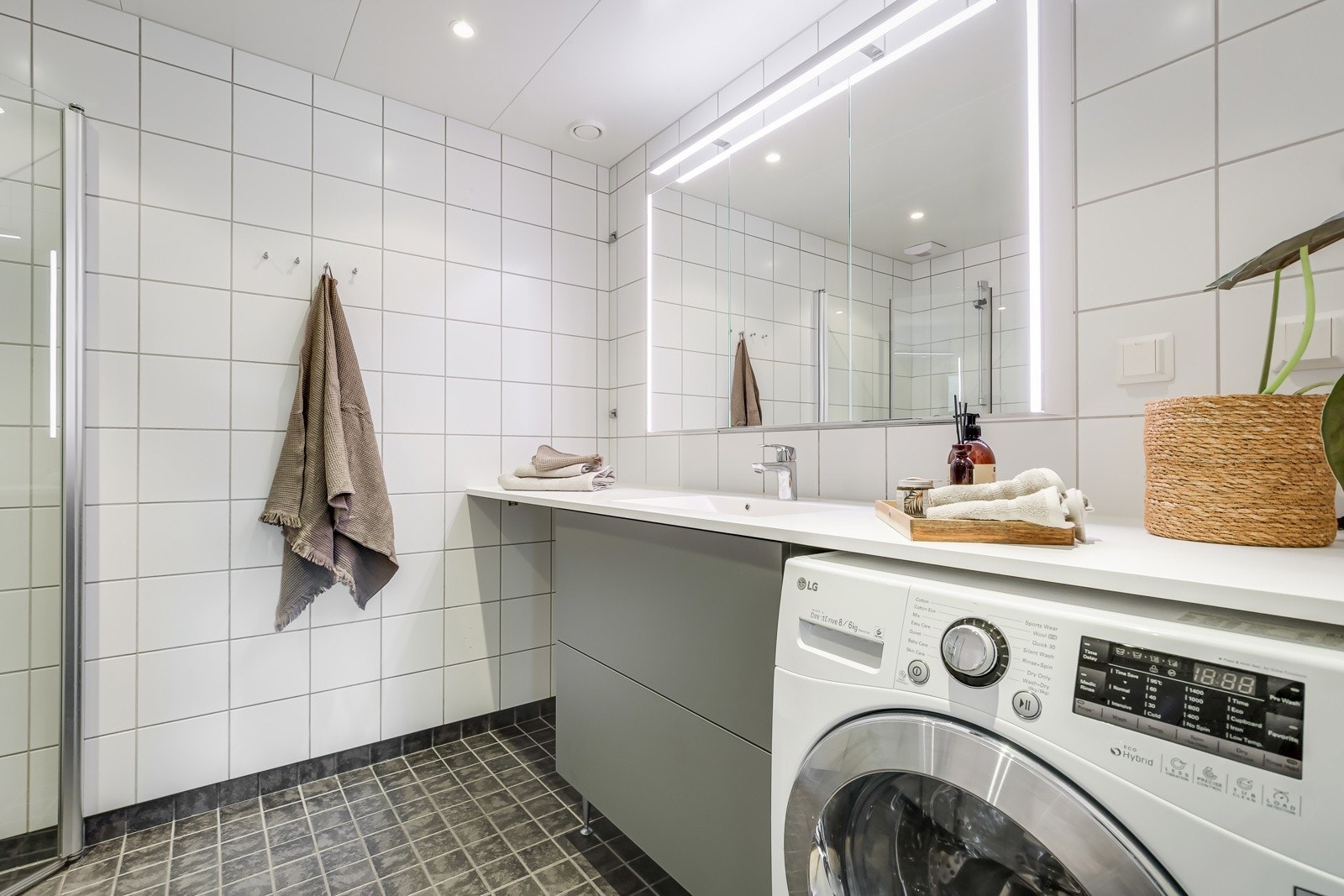 Moderne baderomsinnredning med skuffer og heldekkende servant som gir et rent uttrykk. Baderomsinnredningen er fra 2021, og det er plass til både vaskemaskin og tørketrommel dersom man skulle ønske det. Galleribilde