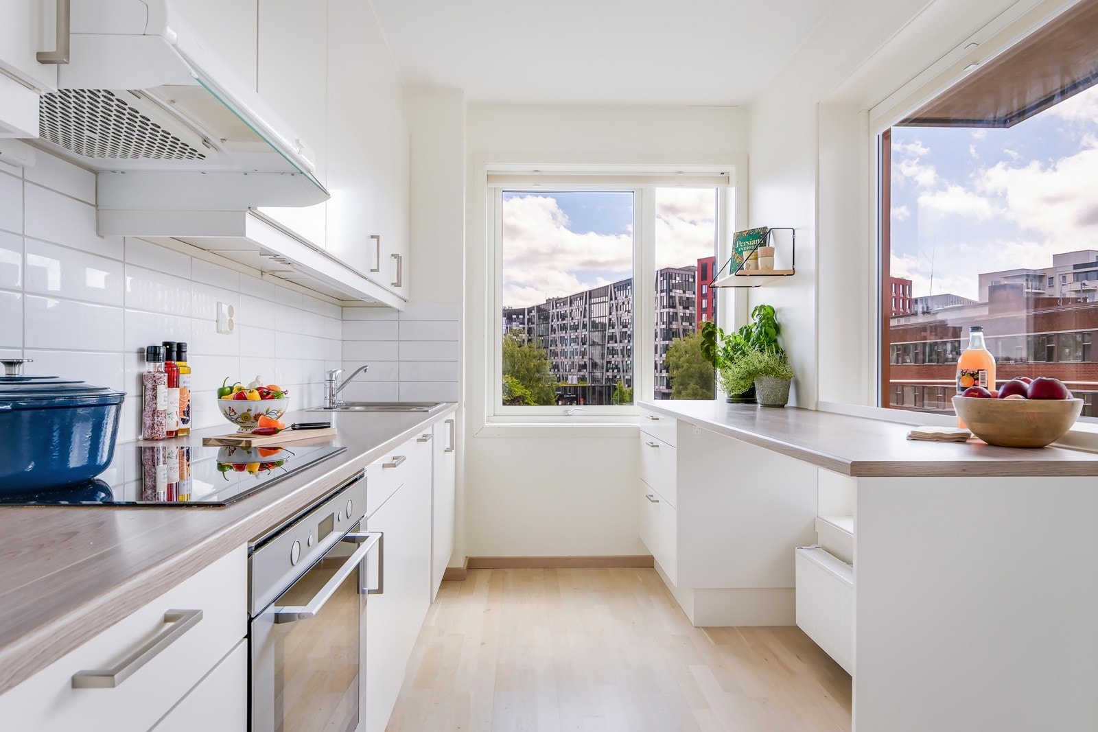 Ved vinduet finner du en praktisk løsning som både gir rikelig med arbeidsflater og en hyggelig sitteplass med barstoler - perfekt for en rask matbit eller samtaler mens du lager middag. Galleribilde