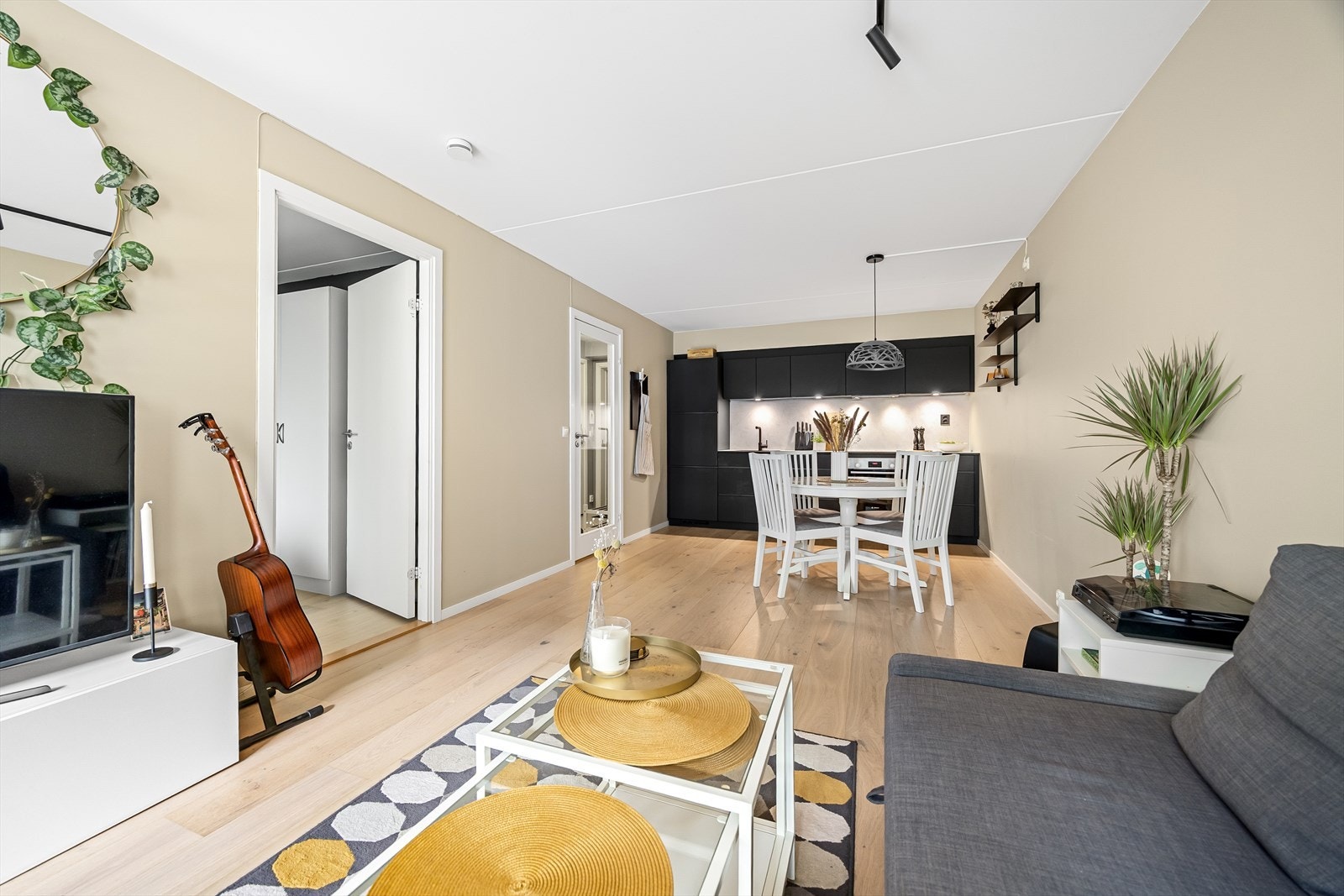 Leilighetens gode planløsning gir muligheter til å innrede i ulike soner med generøs sofagruppe og stort spisebord Galleribilde