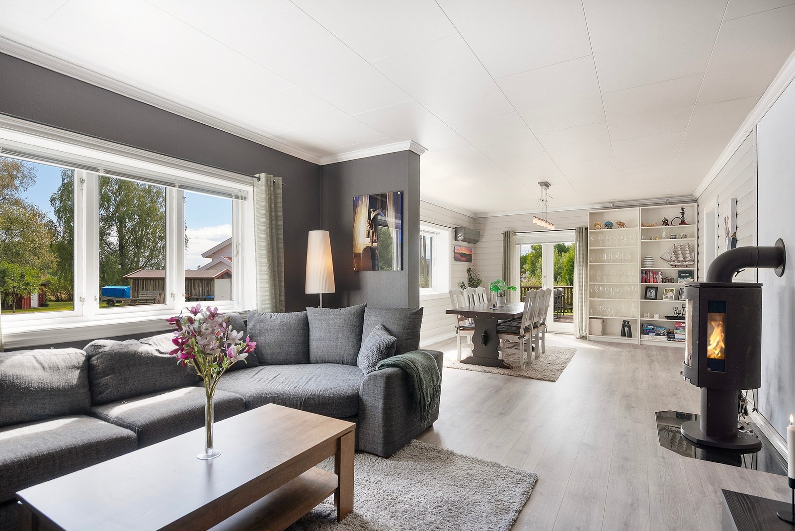 Boligen har en romslig stue hvor fargevalg er brukt bevisst for å skape naturlige soner i rommet Galleribilde