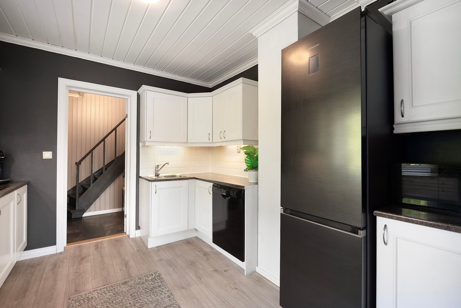 De lyse, profilerte frontene skaper en elegant kontrast til de mørke veggene og benkeplatene, og gir kjøkkenet et tidløst, men samtidig moderne preg Galleribilde