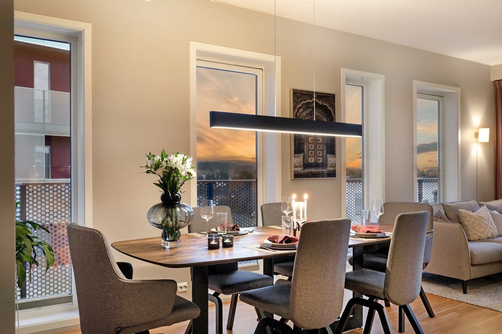 Et trivelig og romslig oppholdsrom med flere store vindusflater Galleribilde