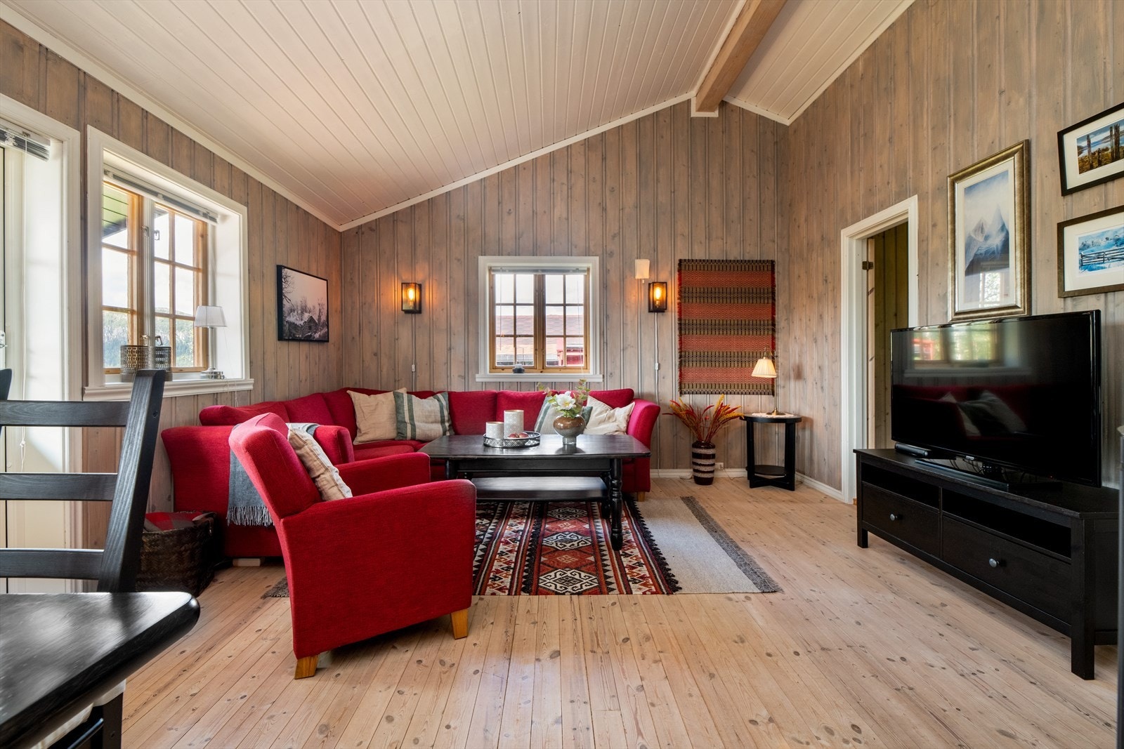 Stuen er lys og trivelig med store vindusflater og god takhøyde. Her er det plass til både sofagruppe og spisestuebord. Galleribilde