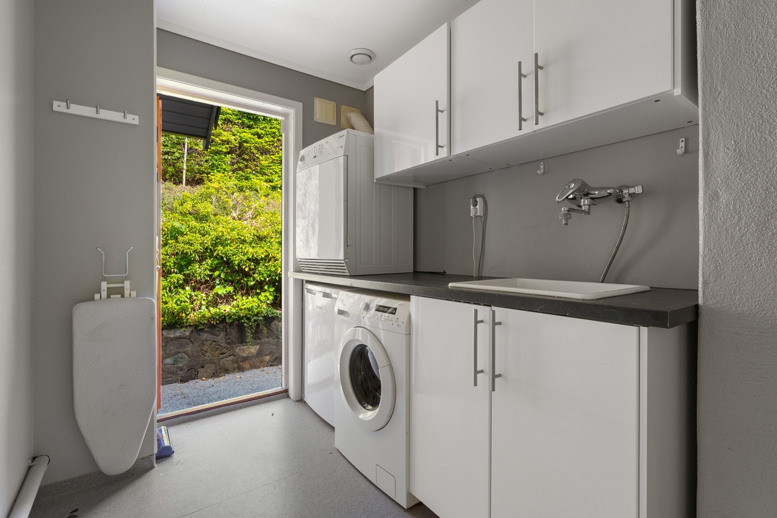 I boligens første etasje finner en også et vaskerom med opplegg for vaskemaskin og tørketrommel. Praktisk med egen inngang til vaskerommet. Galleribilde