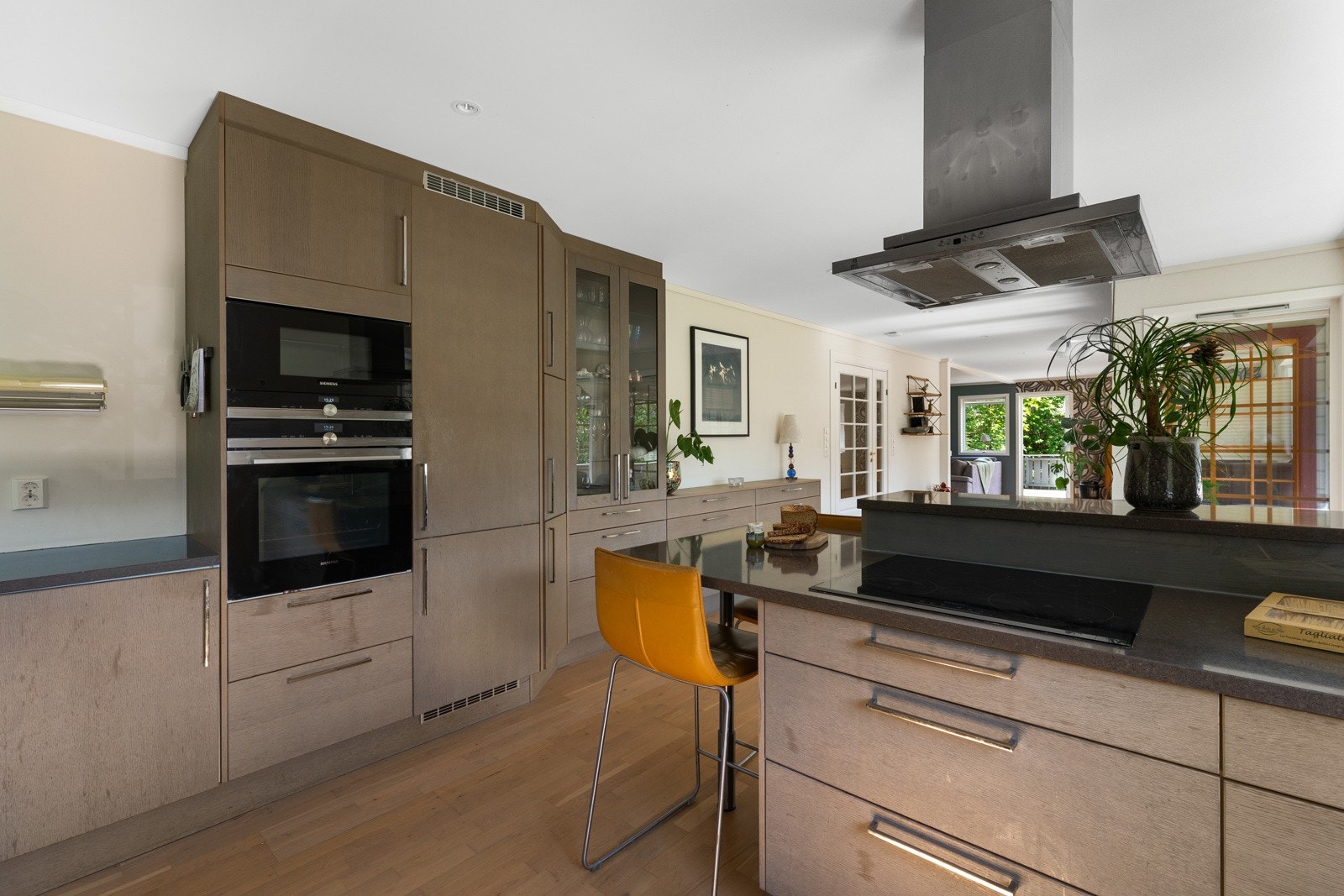 Kjøkkeninnredningen er av glatte fronter og benkeplate i stein med kjøkkenvask. Galleribilde