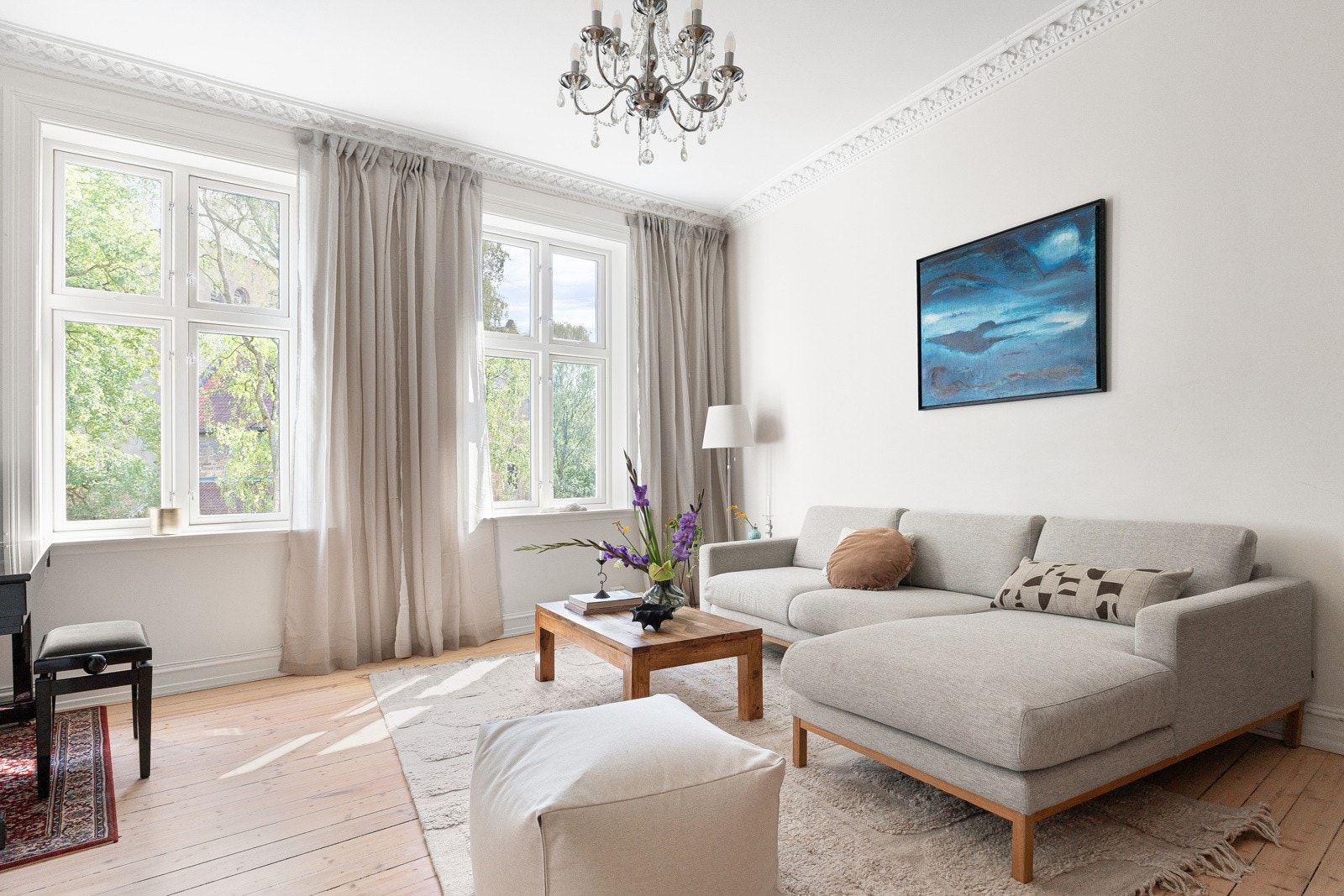Stor og innbydende stue med vakre, klassiske detaljer som stukkatur, rosett og store vindusflater som slipper inn rikelig med naturlig lys. Galleribilde