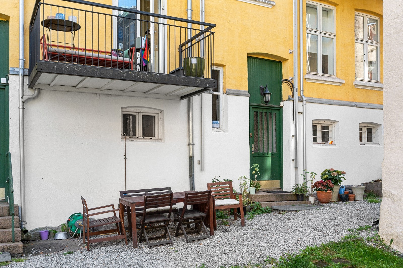Pent opparbeidet bakgård til bruk for beboere. Bakgården har gruslagte gangveier, gressplen med sittegrupper samt diverse busker og beplantinger. Galleribilde