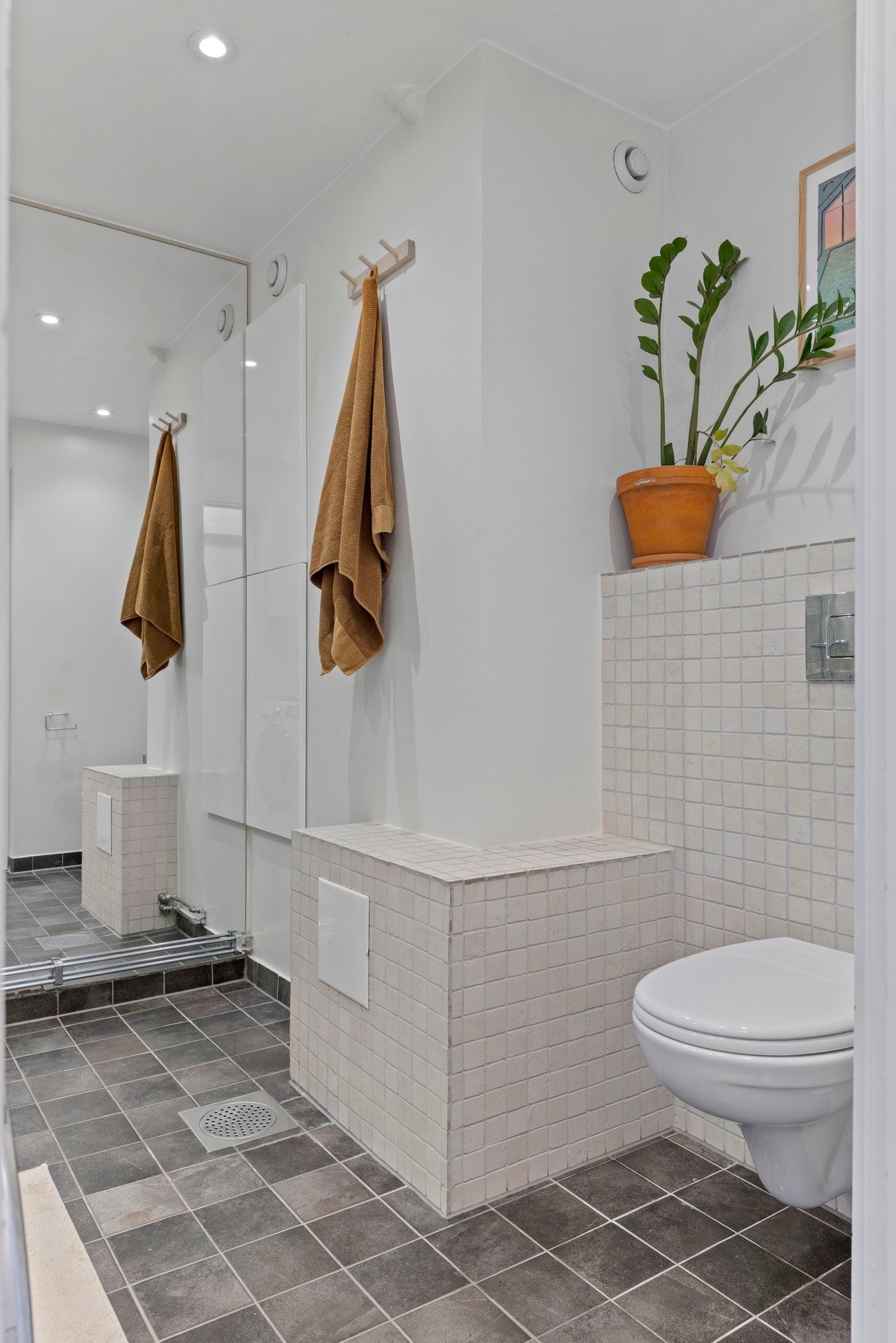 Badet har varmekabler i gulv og opplegg for vaskemaskin Galleribilde