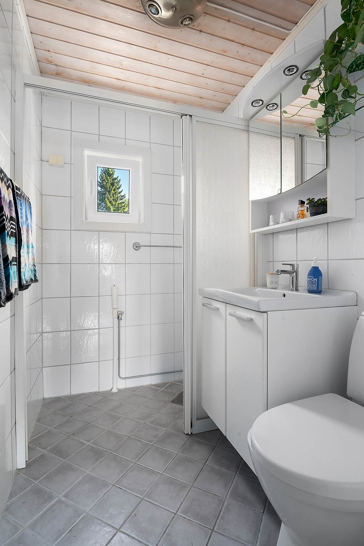 Flislagt bad med varme i gulv, fastmontert gulvklosett, dusjhørne med skyvedør Galleribilde