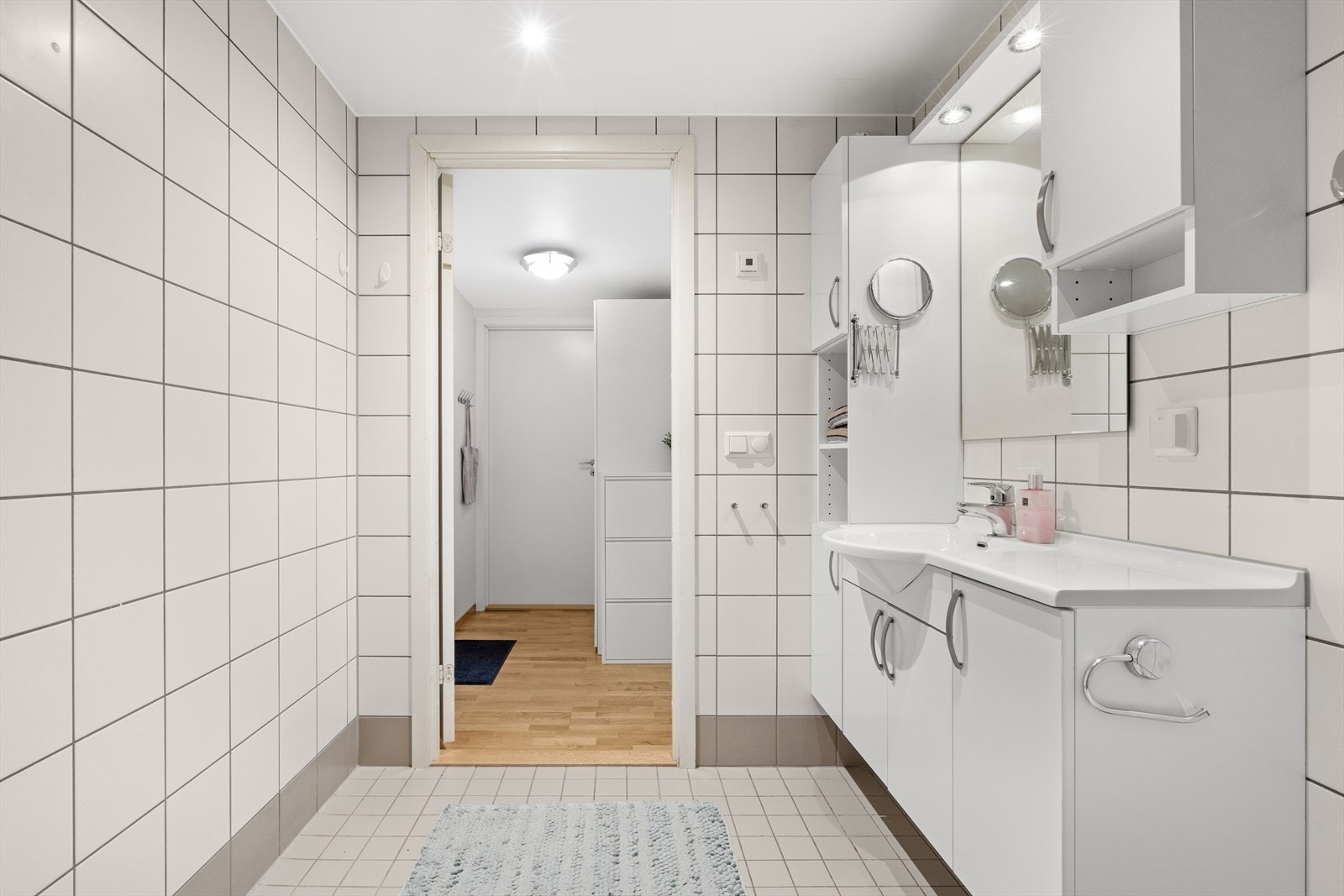 Badet er utført med flislagte overflater i nøytrale farger Galleribilde